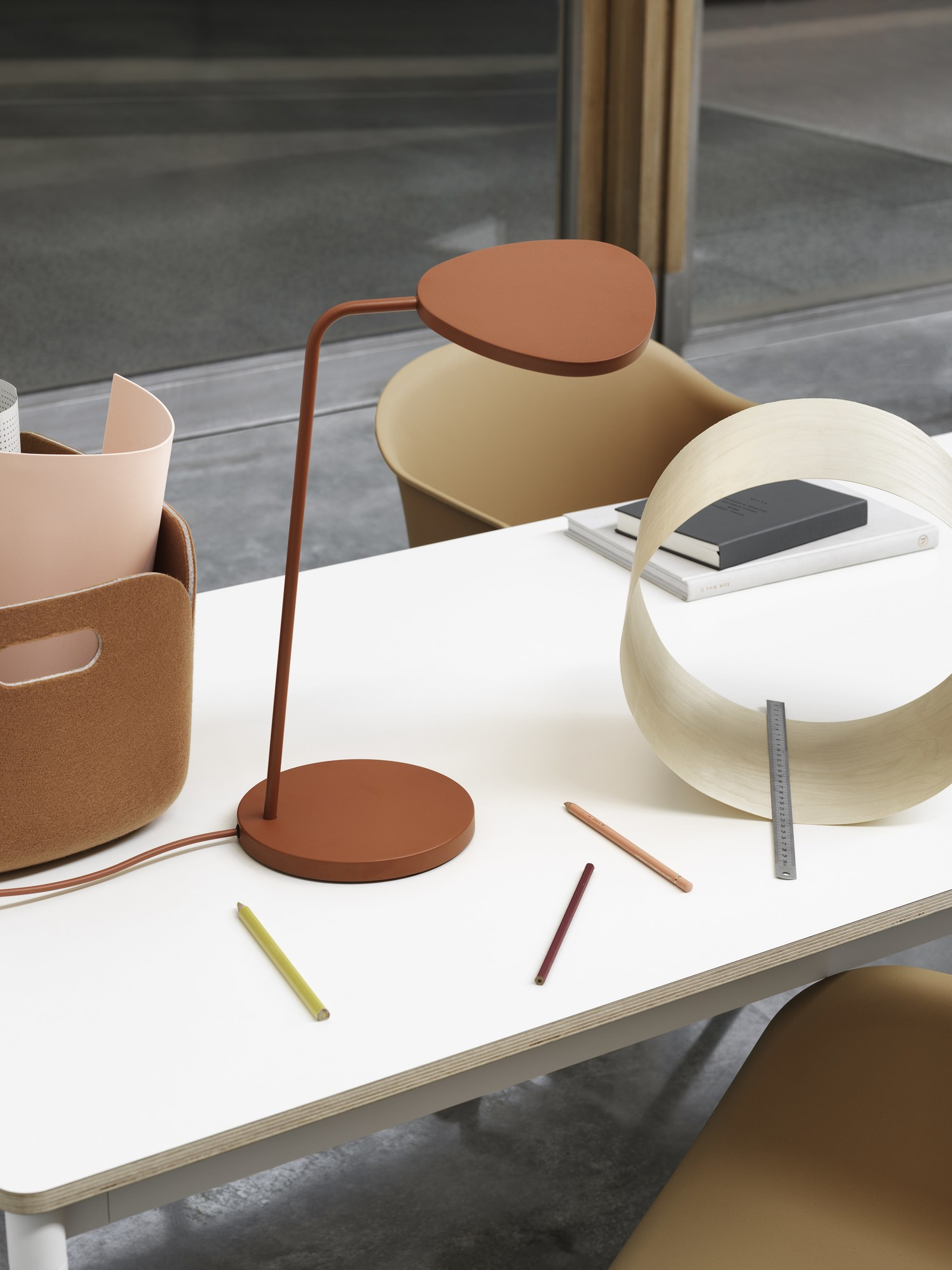 Nahaufnahme des Muuto Restore Aufbewahrungskorbs auf einem Schreibtisch mit Lampe, Stiften und Büroaccessoires.