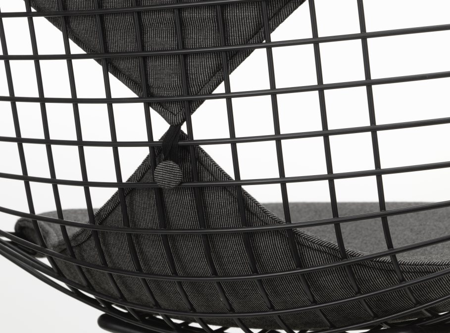 Detailaufnahme des Vitra Wire Chair Bikini Outdoor mit schwarzem Drahtgestell und grauen Kissen.