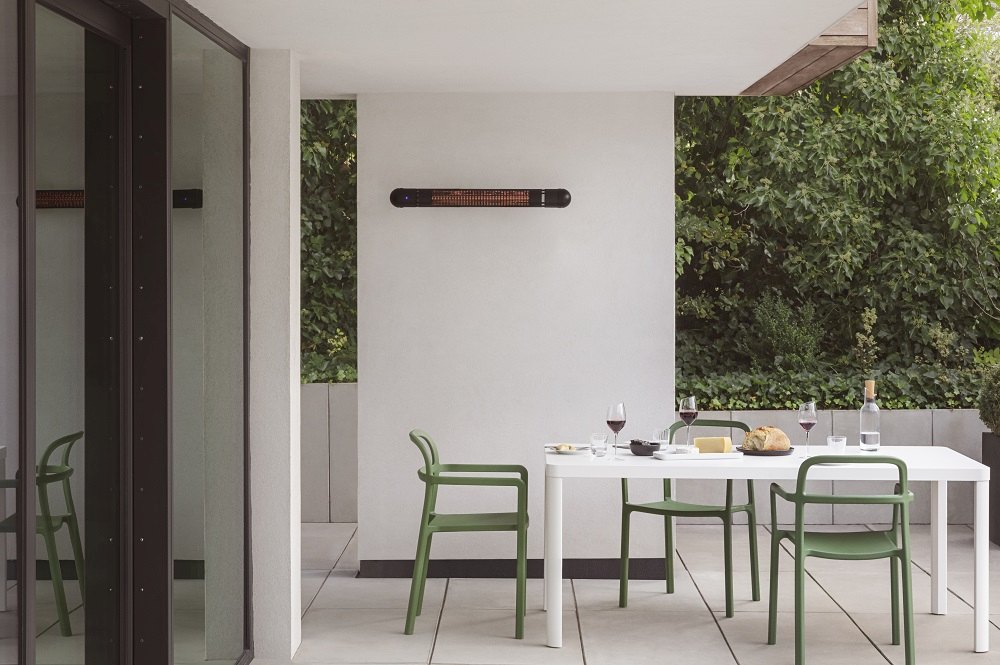 HeatUp Wall Terrassenstrahler von Eva Solo über Esstisch auf einer modernen Terrasse.