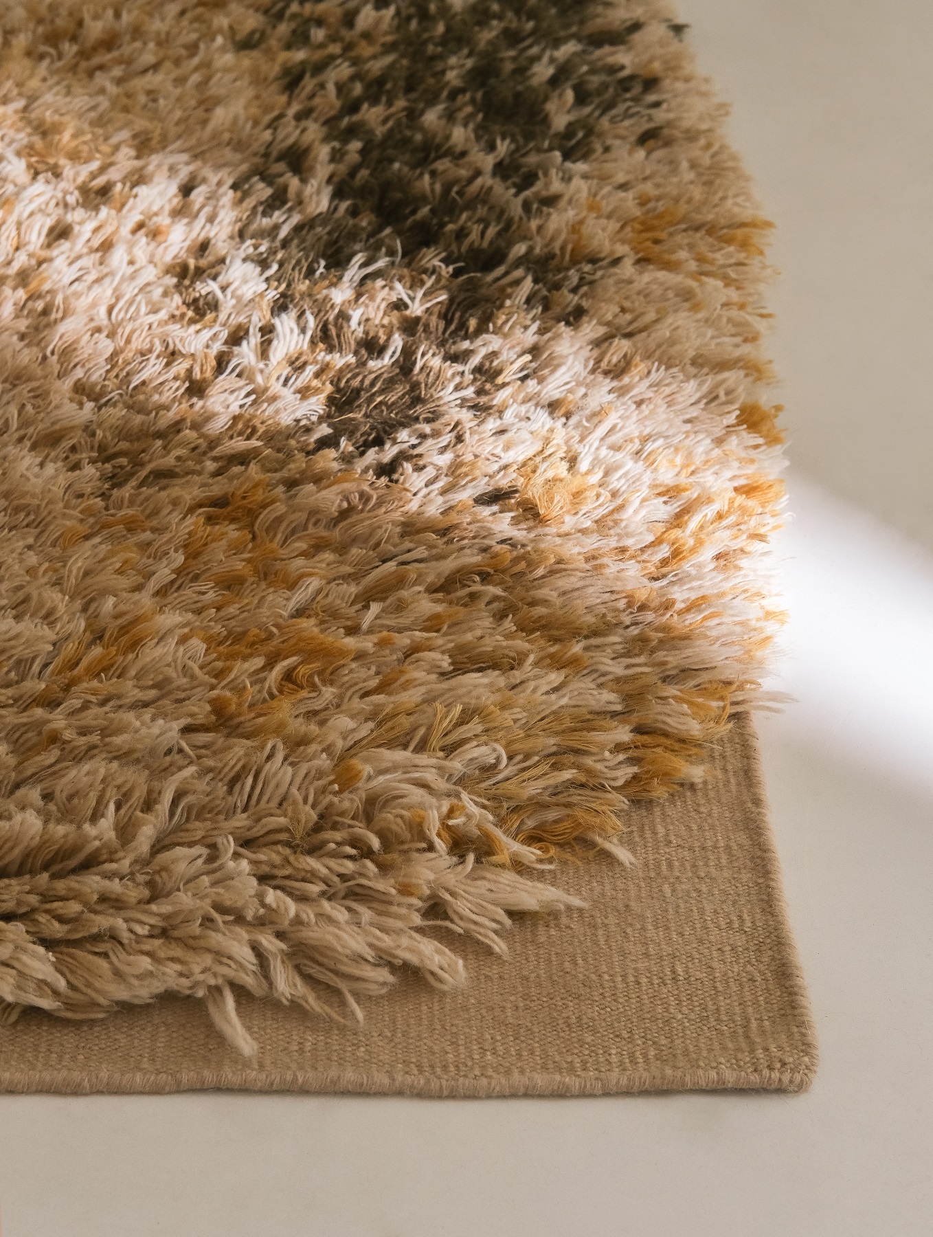 Detailaufnahme des Nanimarquina Alga Rug Teppichs in Beige, Braun und Gelb mit Fransen.