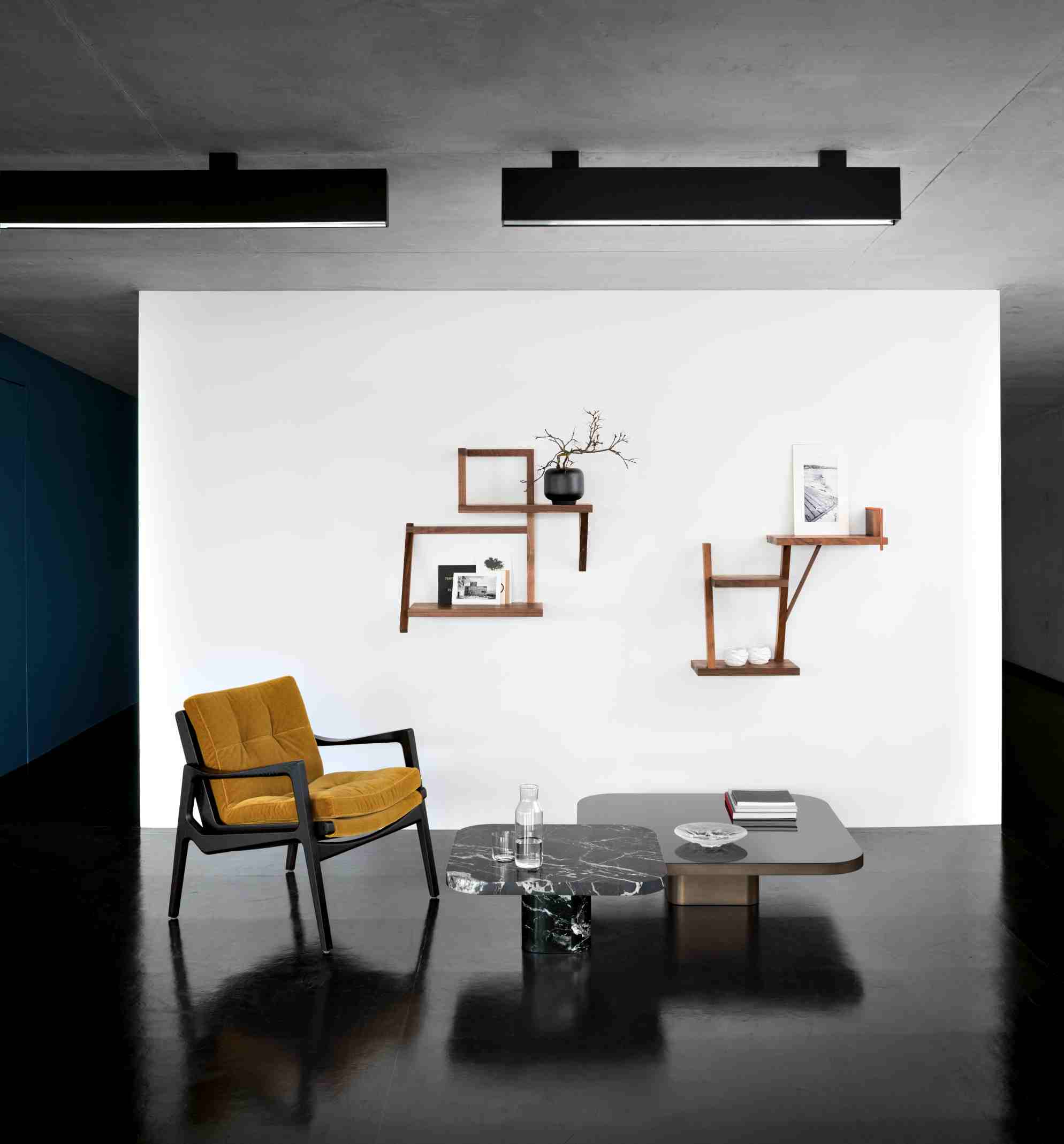 Bow Coffee Table No. 4 ClassiCon in modernem Wohnzimmer mit Sessel und Wandregalen.