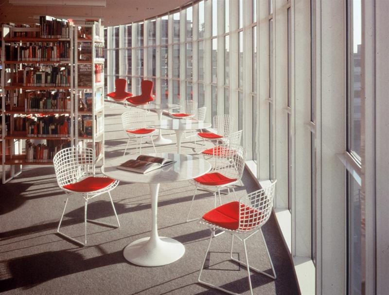 Bertoia Stuhl mit rotem Sitzkissen von Knoll International in einer Bibliothek, Designklassiker.