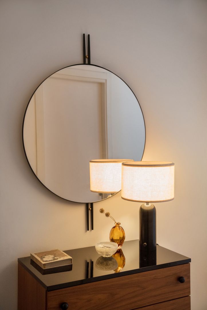 Runder IOI Wandspiegel von Gubi über Kommode mit Lampe und Dekoration. Design Spiegel.