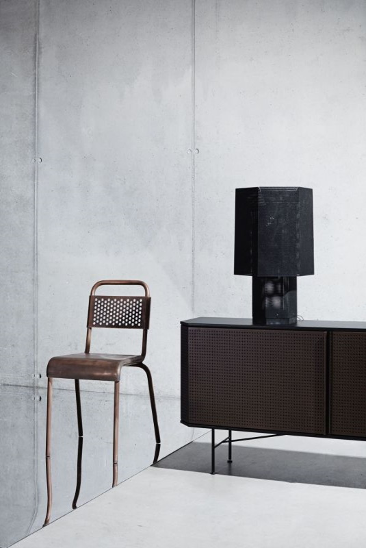 Brauner Metallstuhl, Sideboard mit Lampe im Industriedesign für modernes Wohnzimmer.