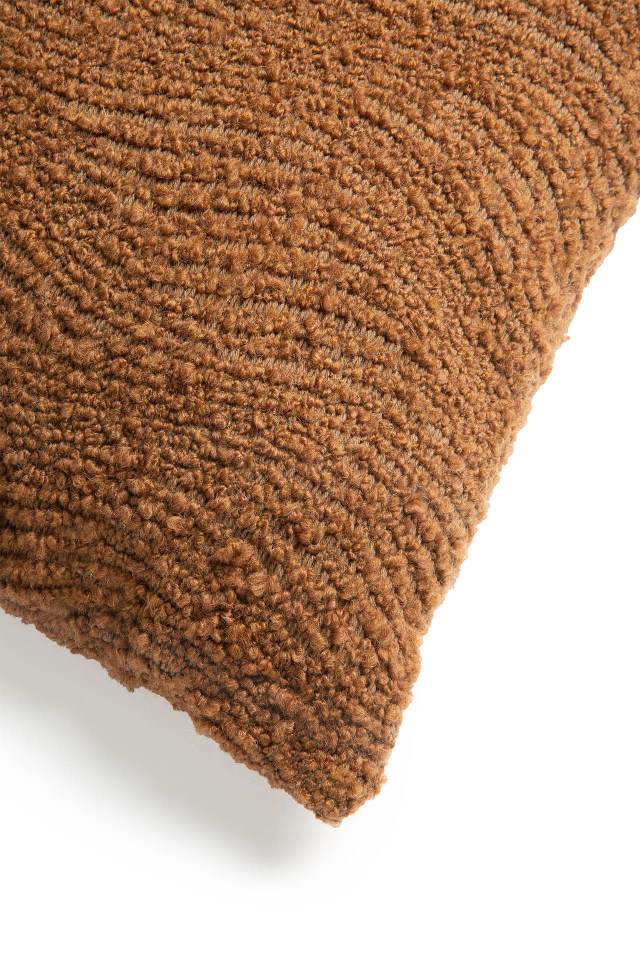 Detailaufnahme des Ethnicraft Wave Cushion Kissens 60x40 cm in Braun mit gewebter Textur.