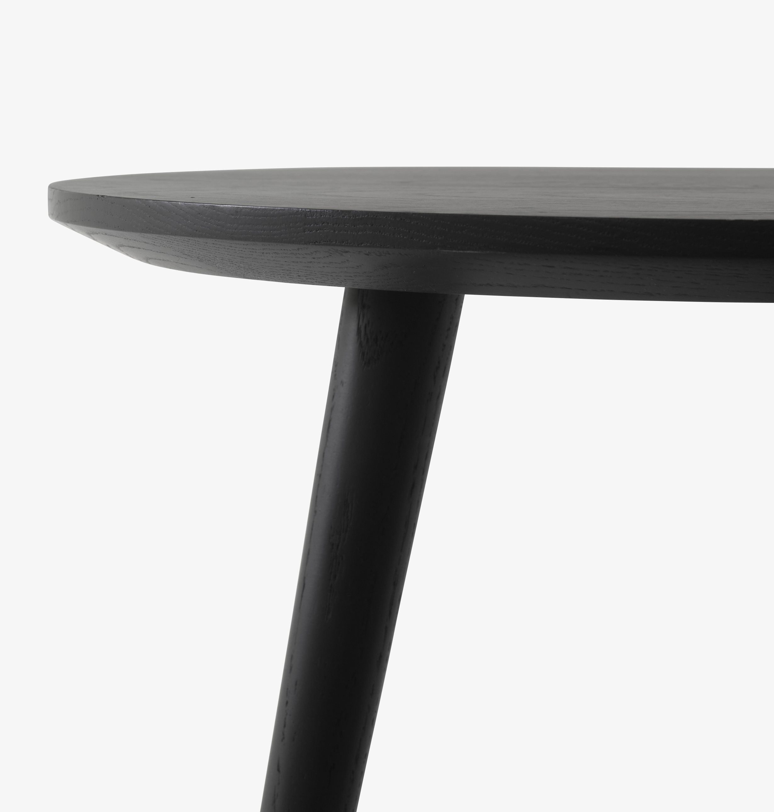 Detailaufnahme des AndTradition In Between Table SK3/SK4 Tisches mit runder, schwarzer Tischplatte und einem Tischbein.