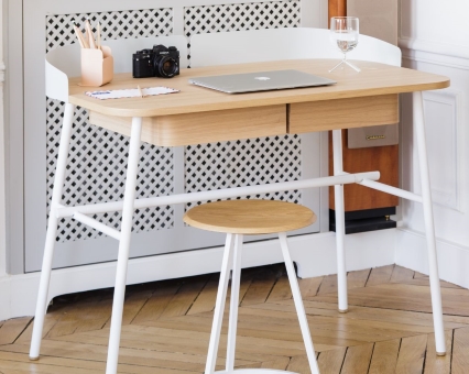 Moderner Schreibtisch aus Holz mit weißen Beinen und passendem Hocker, ideal für Homeoffice und Arbeitszimmer.