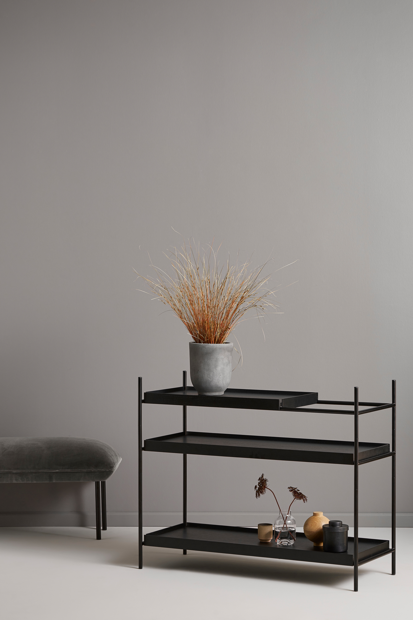 Schwarzes Tray Shelf Low Regal von Woud mit drei Ablagen, dekoriert mit Pflanzen und Vasen.