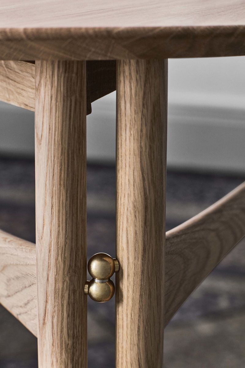 Detailaufnahme des AndTradition Drop Leaf HM5 Beistelltisches aus Eiche mit Messingbeschlägen.