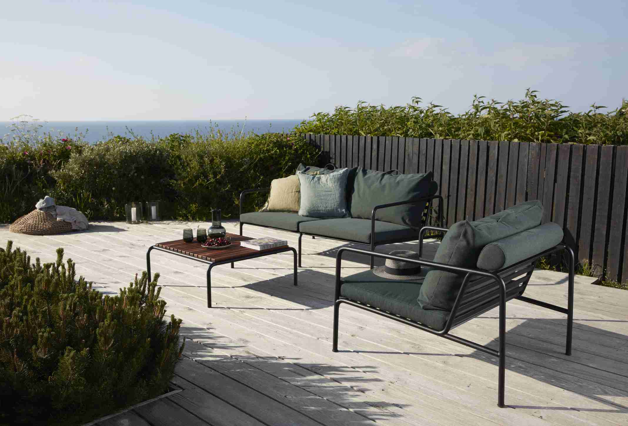 Avon Lounge Chair Outdoor Sessel von Houe mit Sofa und Tisch auf einer Holzterrasse.