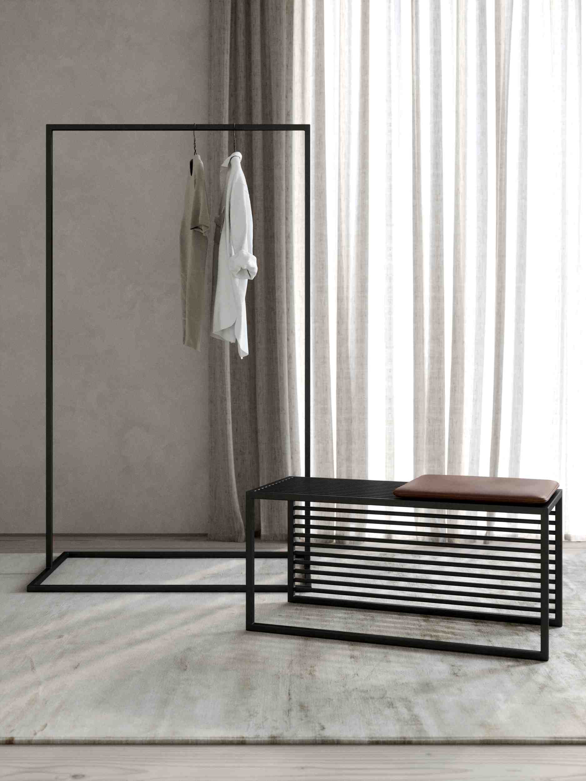 Novoform Element Bank mit schwarzem Metallgestell und braunem Sitzkissen, kombiniert mit minimalistischer Kleiderstange.