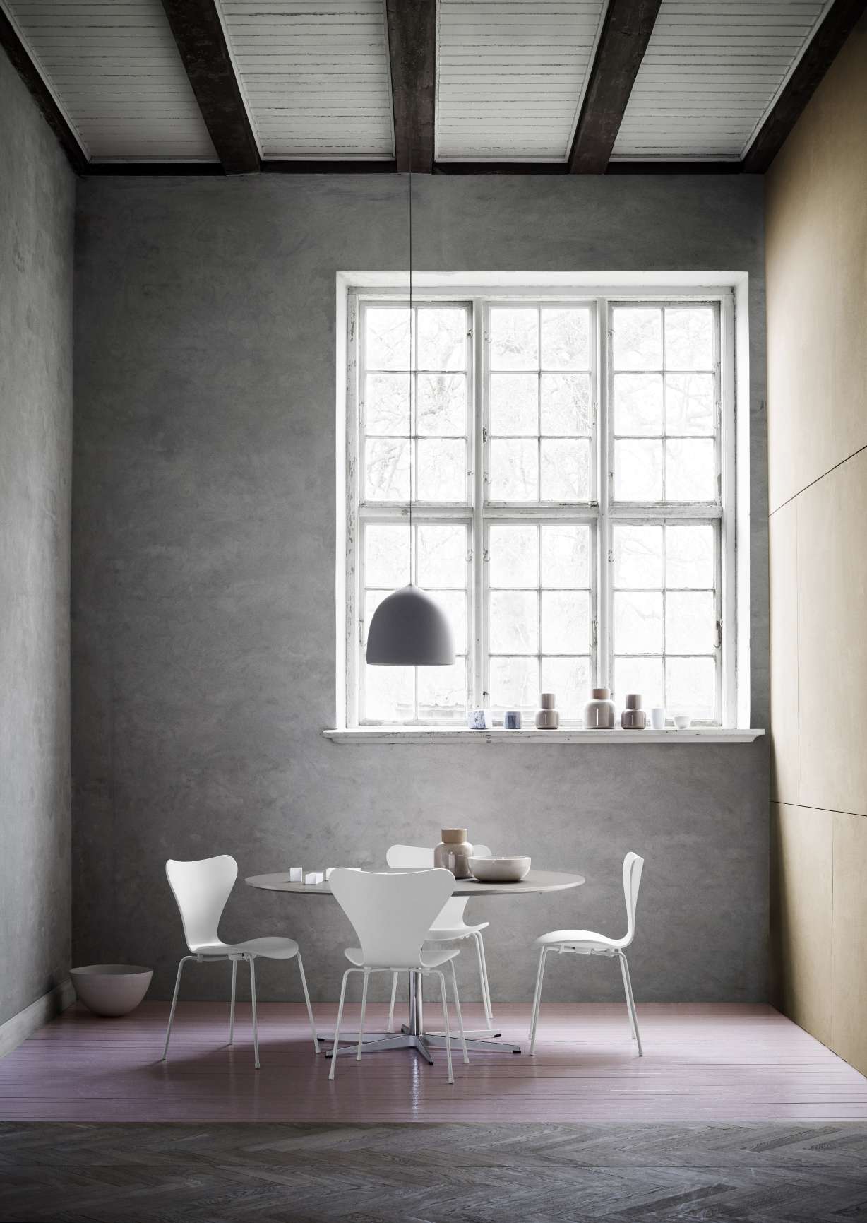 Zirkular Tisch von Fritz Hansen, runder Esstisch mit weißen Stühlen in modernem Interieur.