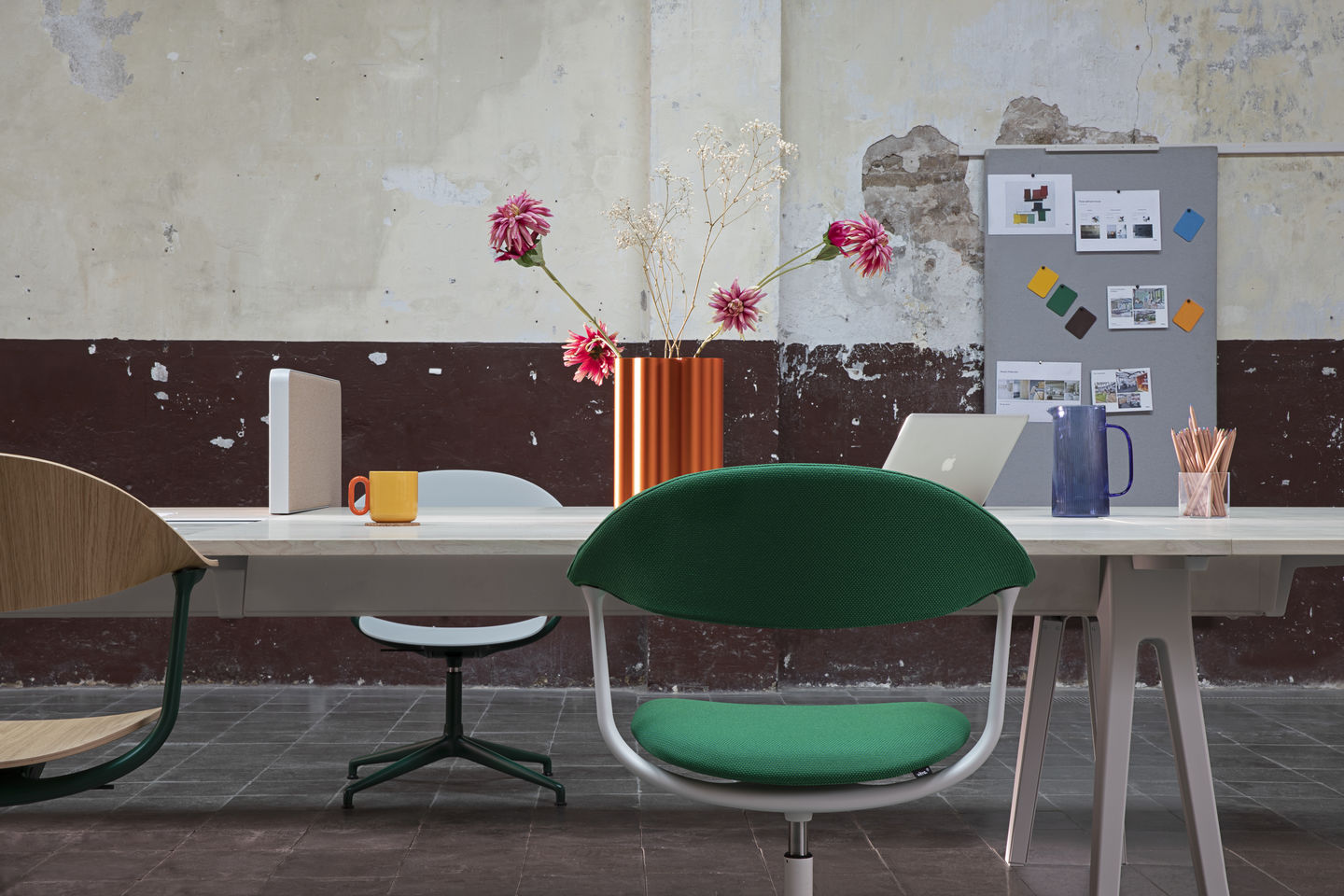 Mynt Bürostuhl von Vitra mit Holzlehne und grüner Sitzfläche am Schreibtisch.