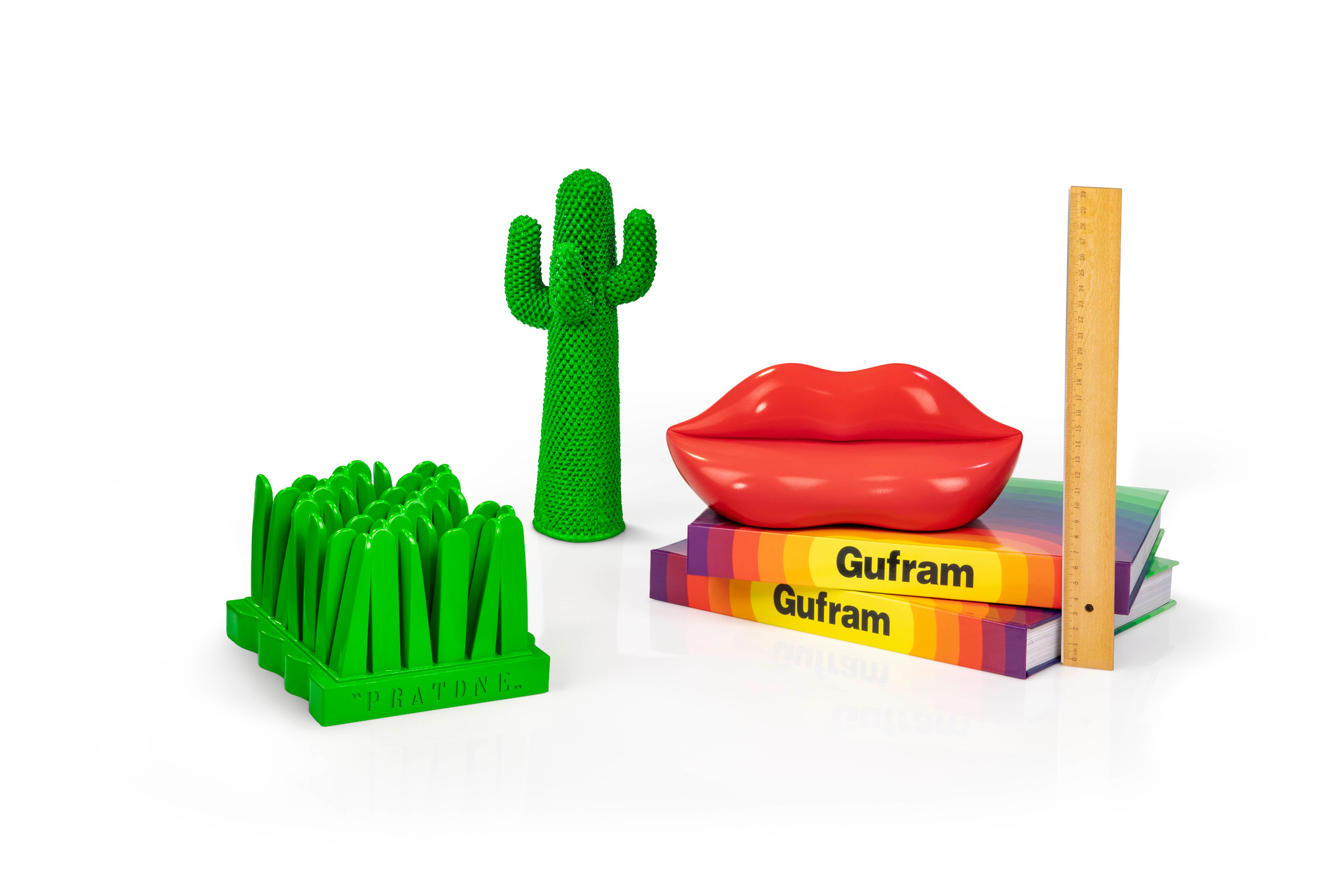 Guframini Bocca Miniatur, grüner Kaktus und Gras Designobjekt auf Büchern mit Lineal, modernes Wohnaccessoire.