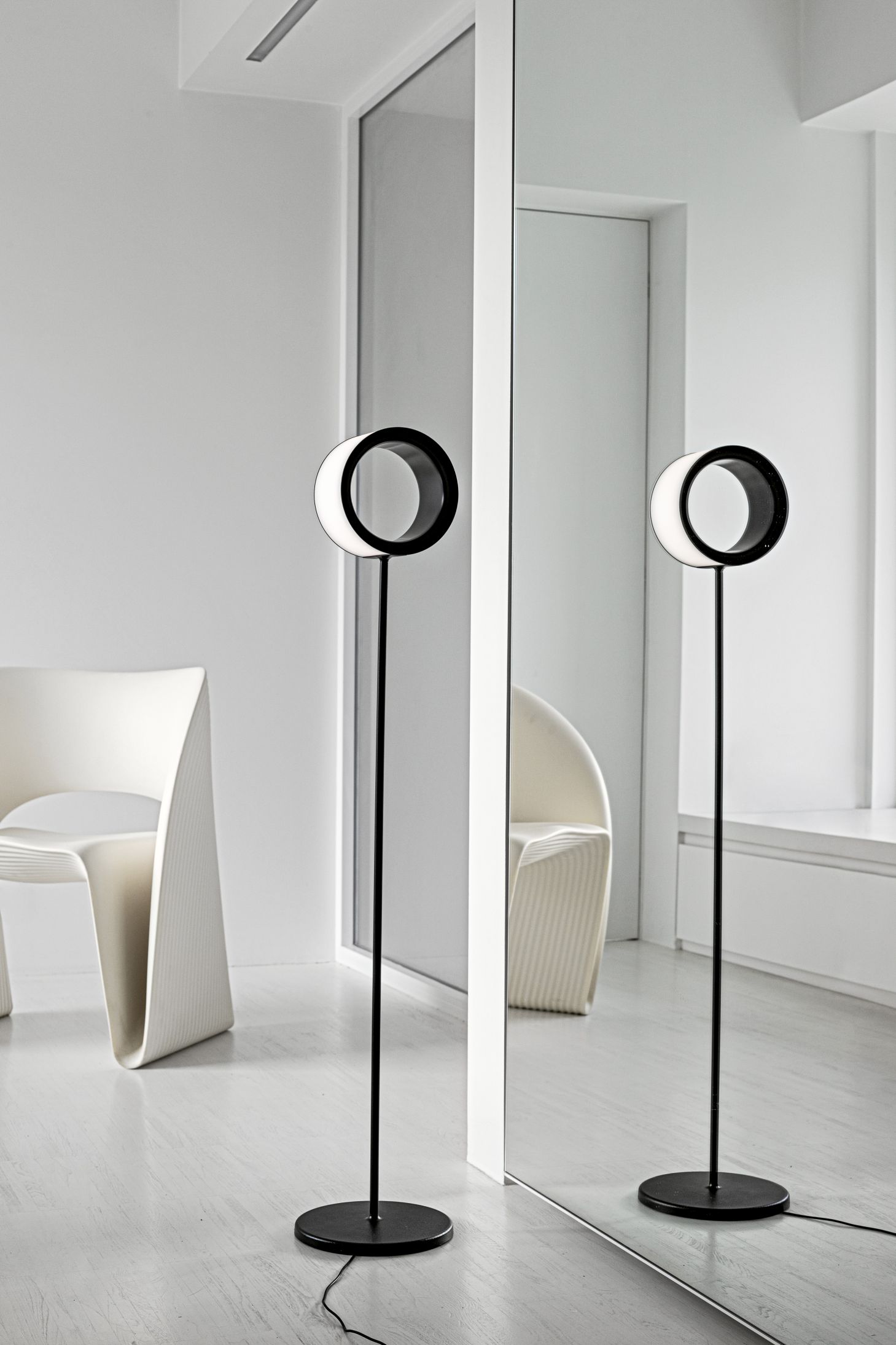 Lost Stehleuchte von Magis: Moderne Stehlampe mit kreisförmigem Lampenschirm in Schwarz und Weiß.