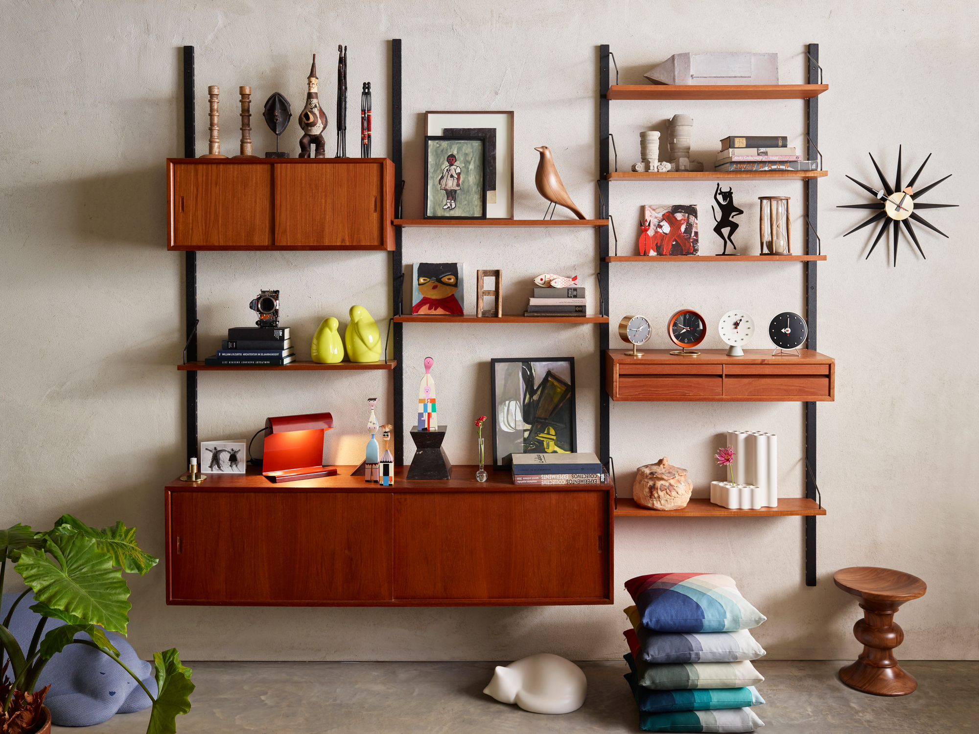 Regalsystem mit Vitra Chronopak Tischuhren und Deko-Objekten, modernes Wohnzimmer Interieur mit Designklassikern.