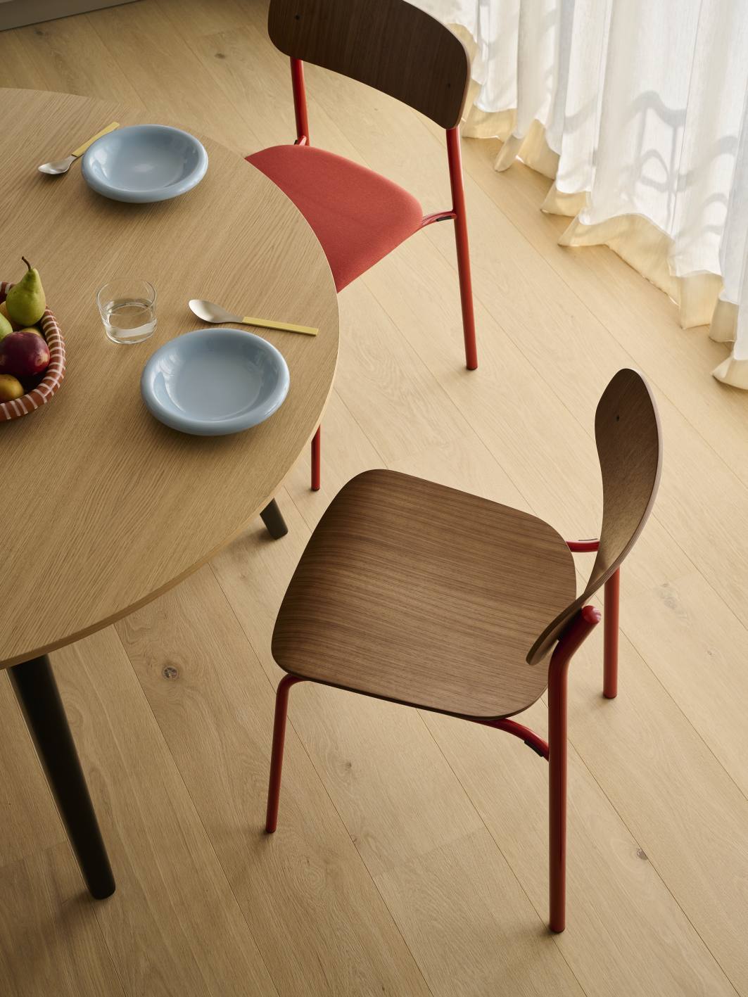 S 243 Stahlrohrstuhl von Thonet, Einzelstück mit Holzlehne und rotem Stahlrohrgestell am Esstisch.