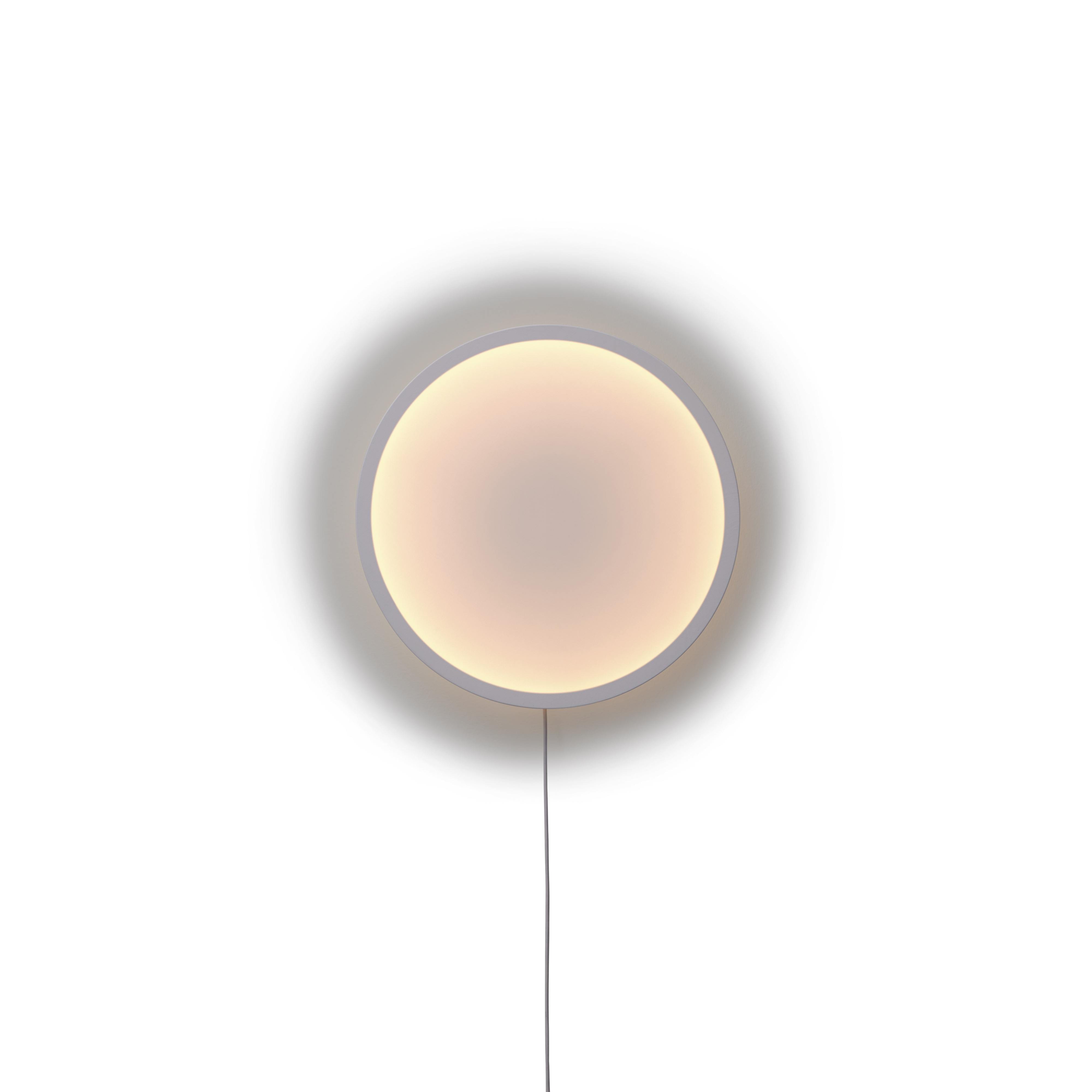 Nahaufnahme der runden Calm Wall Lamp Wandleuchte von Muuto mit sanftem, warmem Licht.