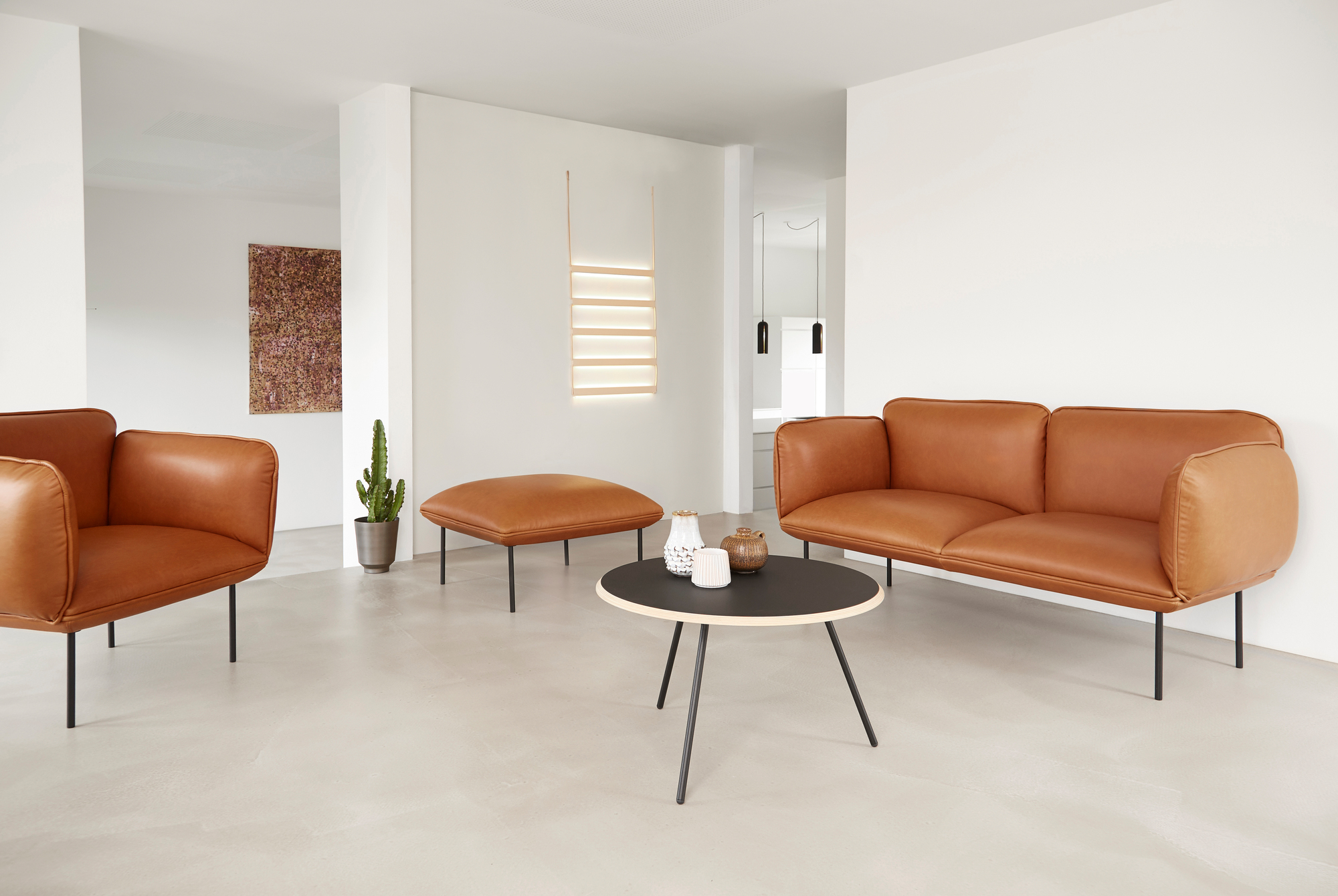 Beiger Soround Coffee Table Couchtisch von Woud mit schwarzer Tischplatte und filigranem Metallgestell im Wohnzimmer.