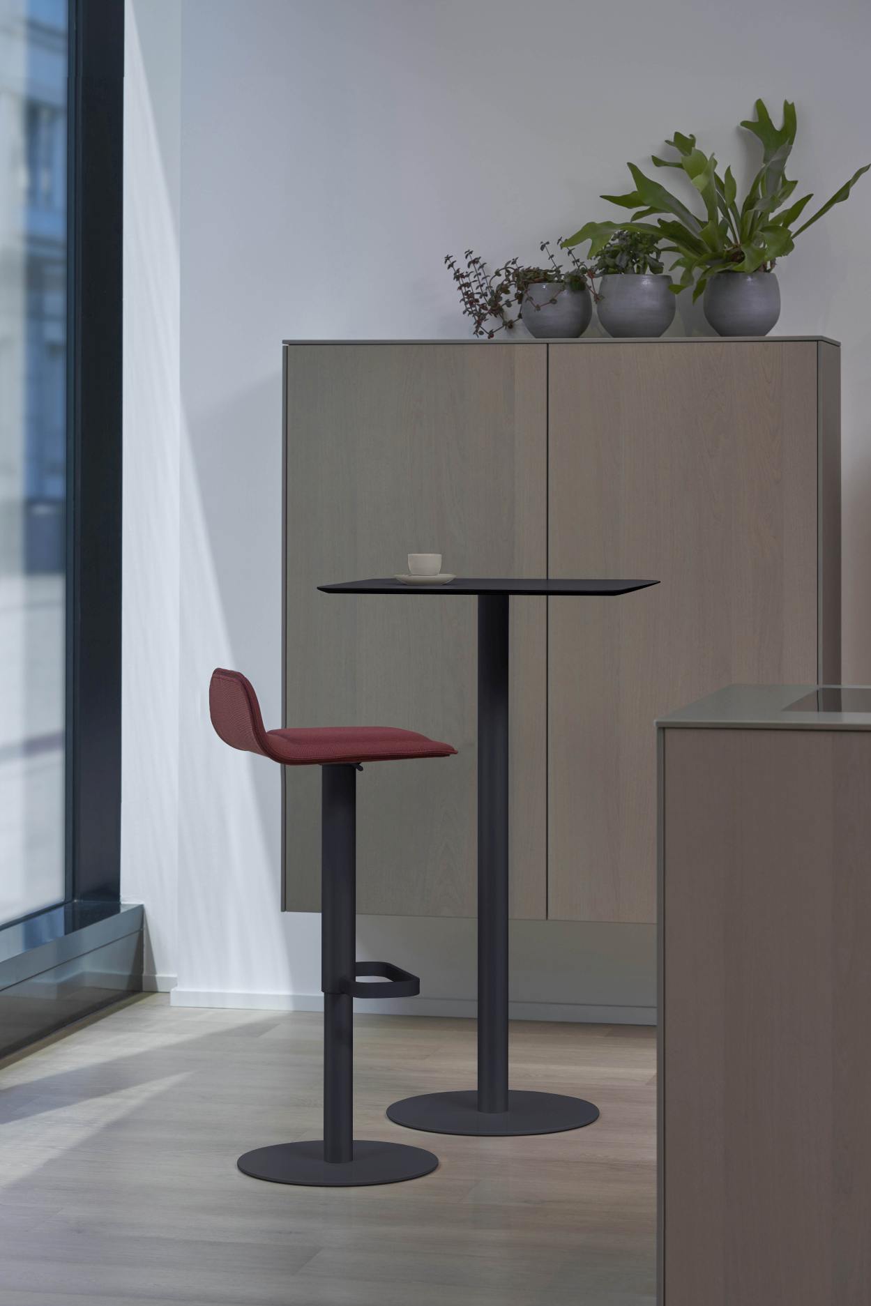 Anthrazitfarbener Moree Stehtisch für Innenräume mit passendem Barhocker, ideal für moderne Büros und Wohnräume.