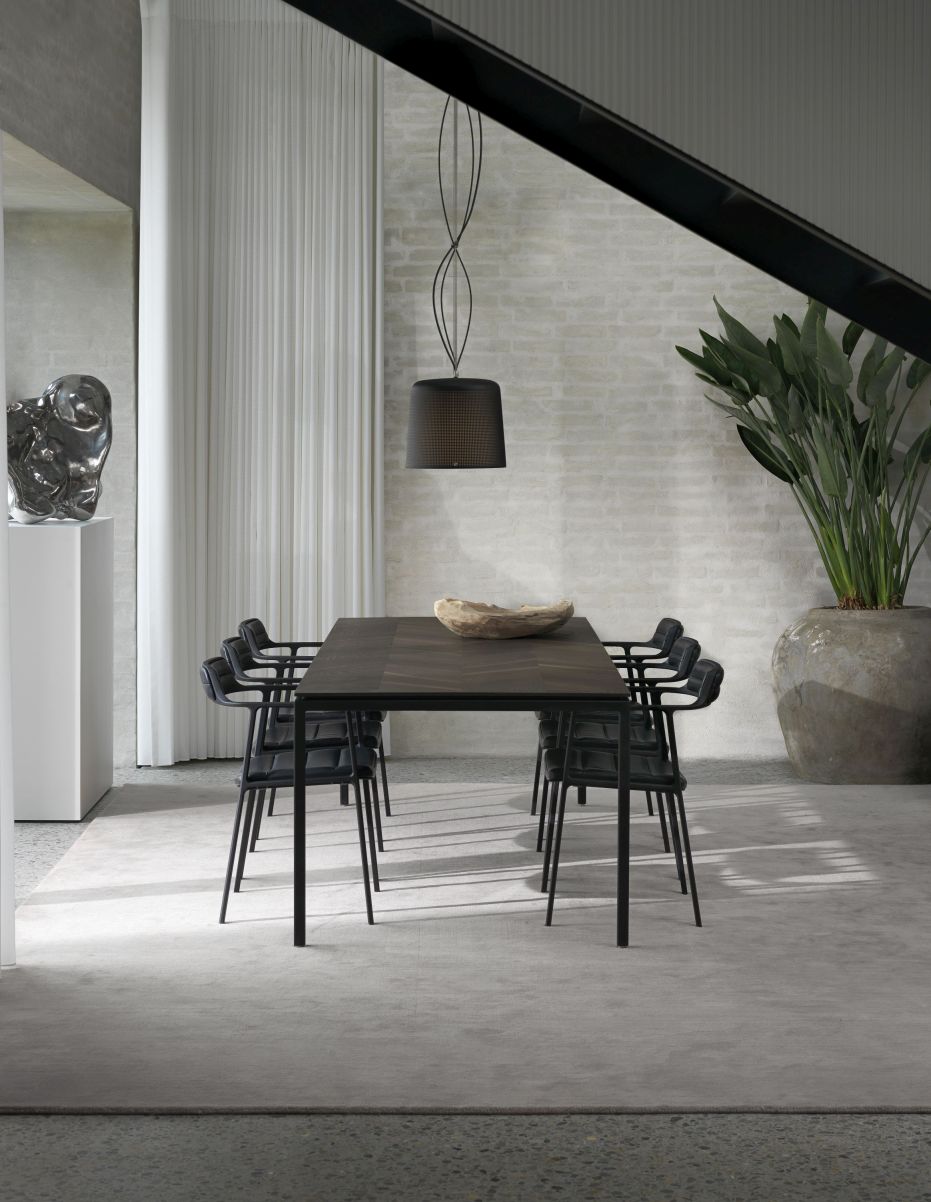 Moderner Esstisch aus dunklem Holz mit schwarzen Stühlen und Designer-Hängeleuchte für stilvolles Esszimmer.