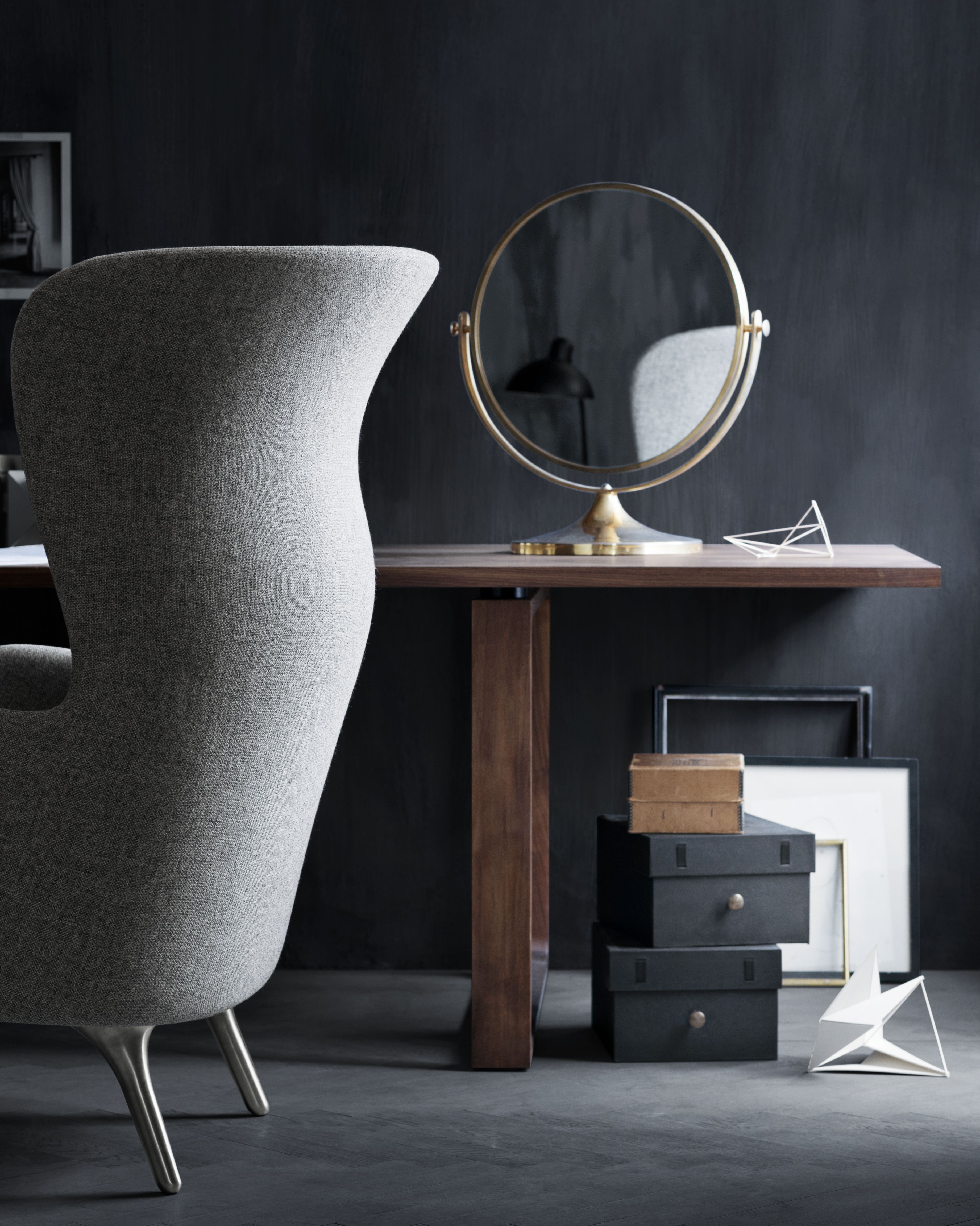 Grauer Ro Sessel von Fritz Hansen mit hohem Rückenlehne und filigranen Füßen neben Schreibtisch.