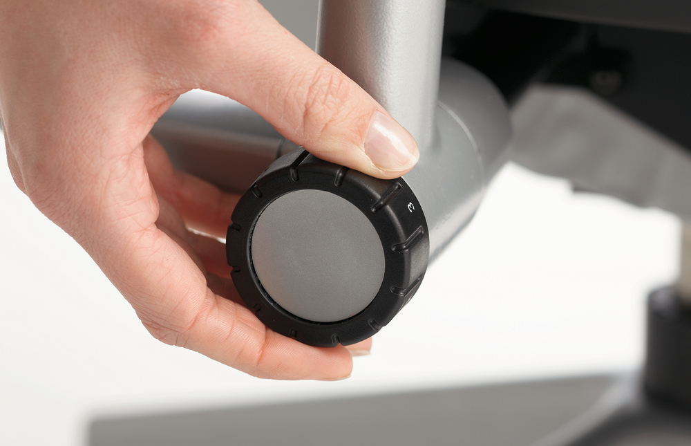 Hand justiert Drehknopf am Steelcase Please Bürostuhl zur optimalen Sitzeinstellung.