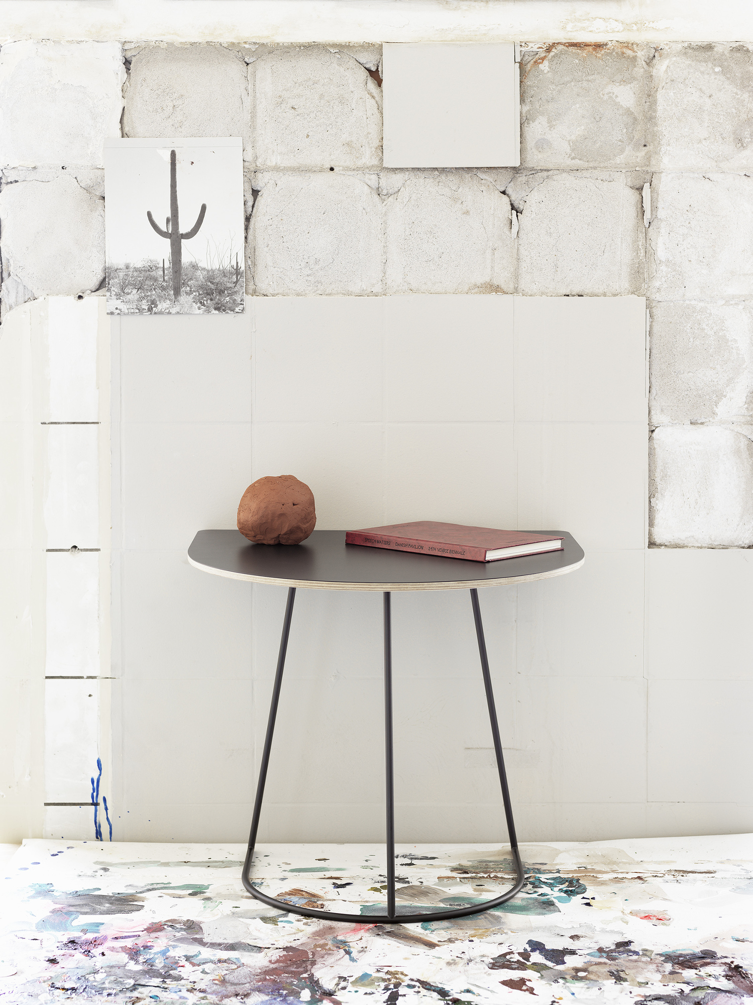 Airy Coffee Table Beistelltisch von Muuto mit schwarzer Tischplatte und drei Beinen im Interieur.