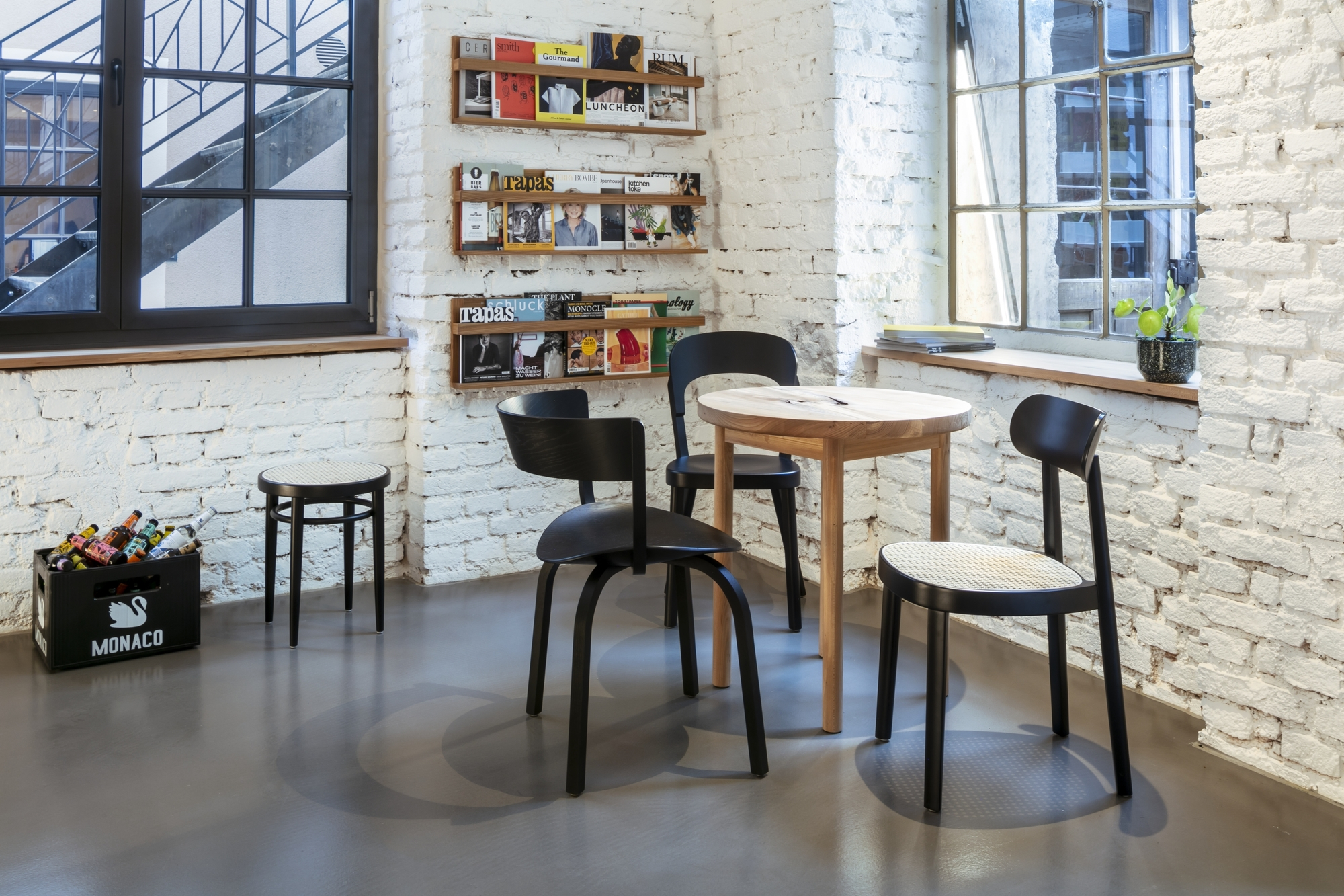 Schwarzer Holzstuhl Thonet 118 mit Wiener Geflecht Sitzfläche am Holztisch in modernem Ambiente.