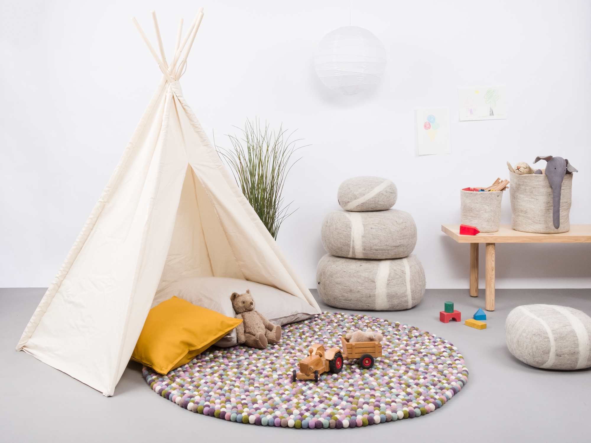 Runder Filzkugel Teppich von myfelt, 180 cm Durchmesser, im Kinderzimmer mit Spielzeug.