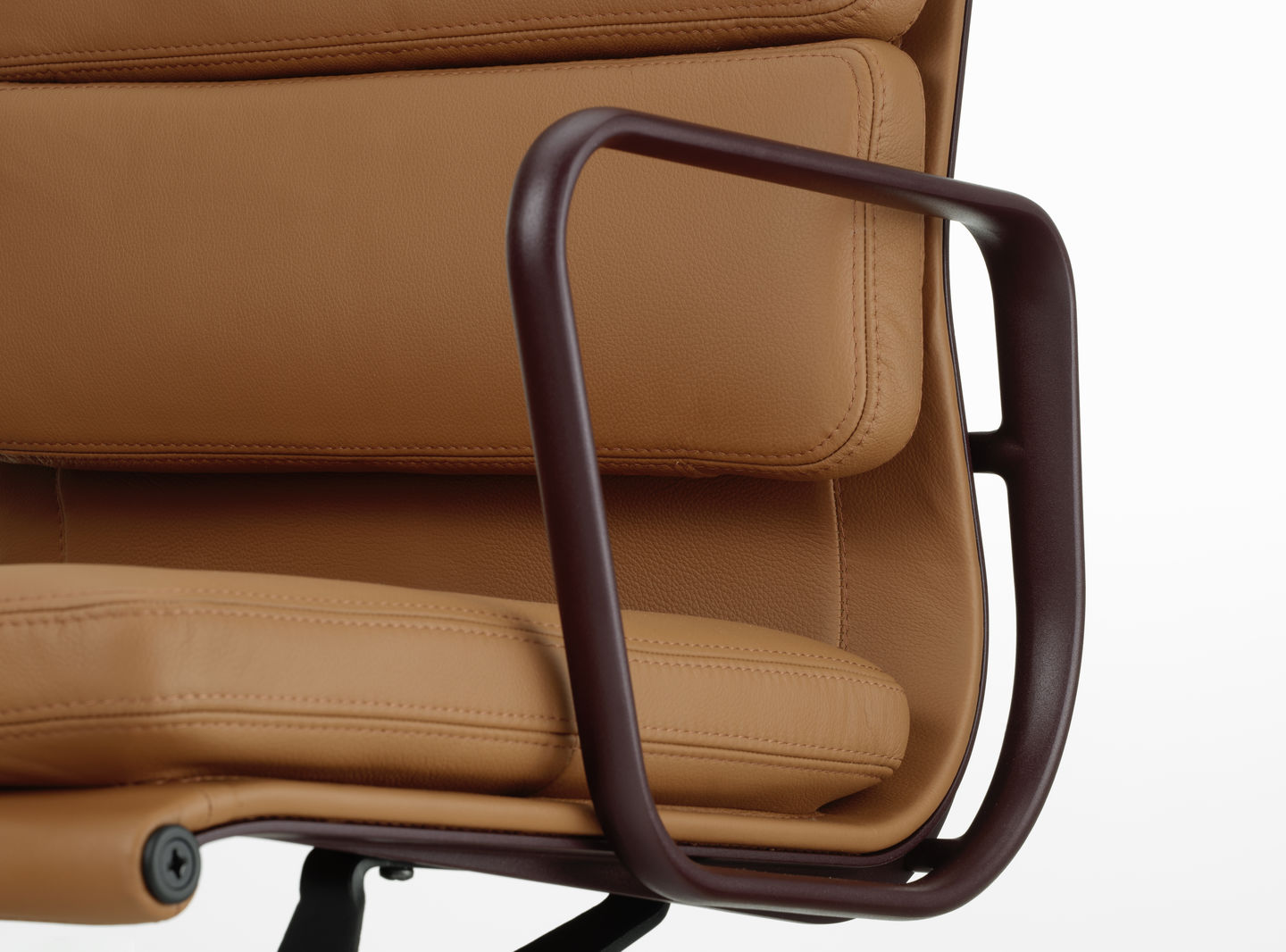 Detailaufnahme des Soft Pad Chair EA219 von Vitra mit braunem Lederbezug und Armlehne.