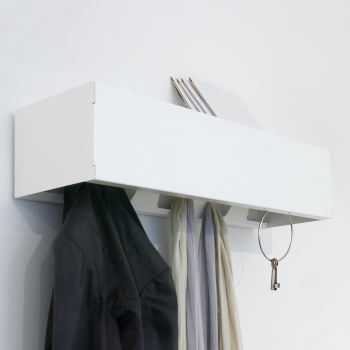 Weiße Wandgarderobe CR Linea1 mit Jacke, Schals und Schlüssel an der Wand befestigt.