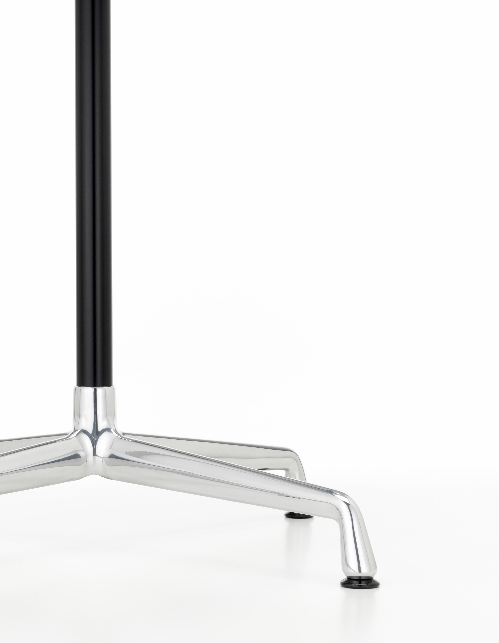Detailaufnahme des Fußgestells vom Vitra Eames Contract Table mit schwarzer Säule und verchromten Beinen.