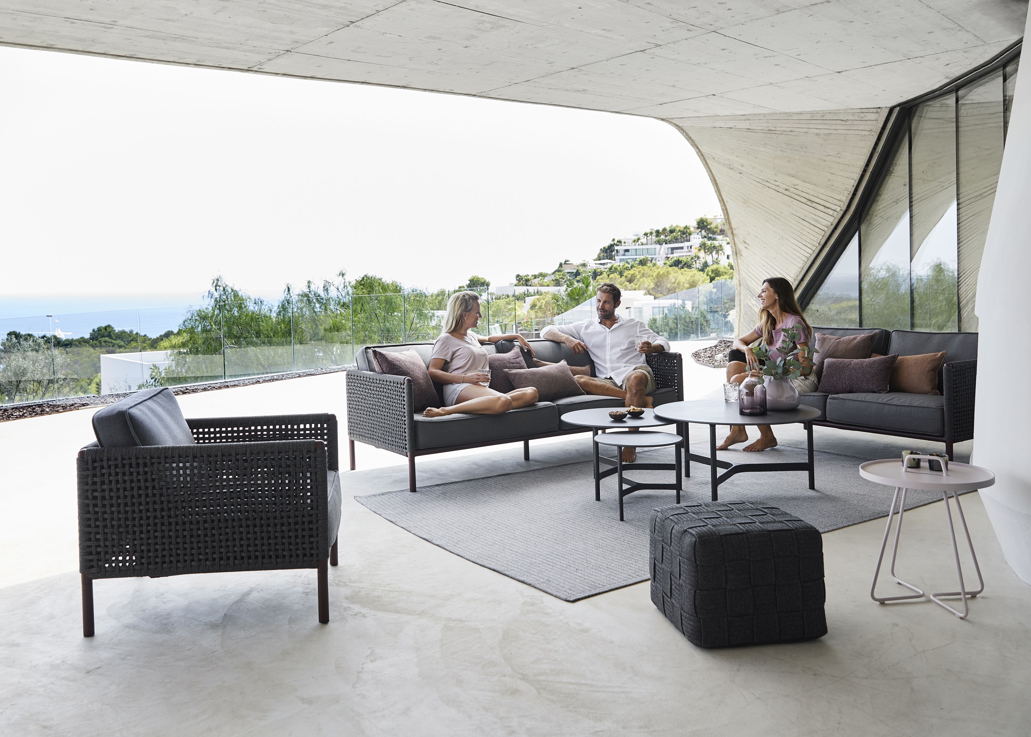 Encore Sofa von Cane-Line auf Terrasse mit Menschen. Gartenmöbel, Outdoor Sofa, Design.
