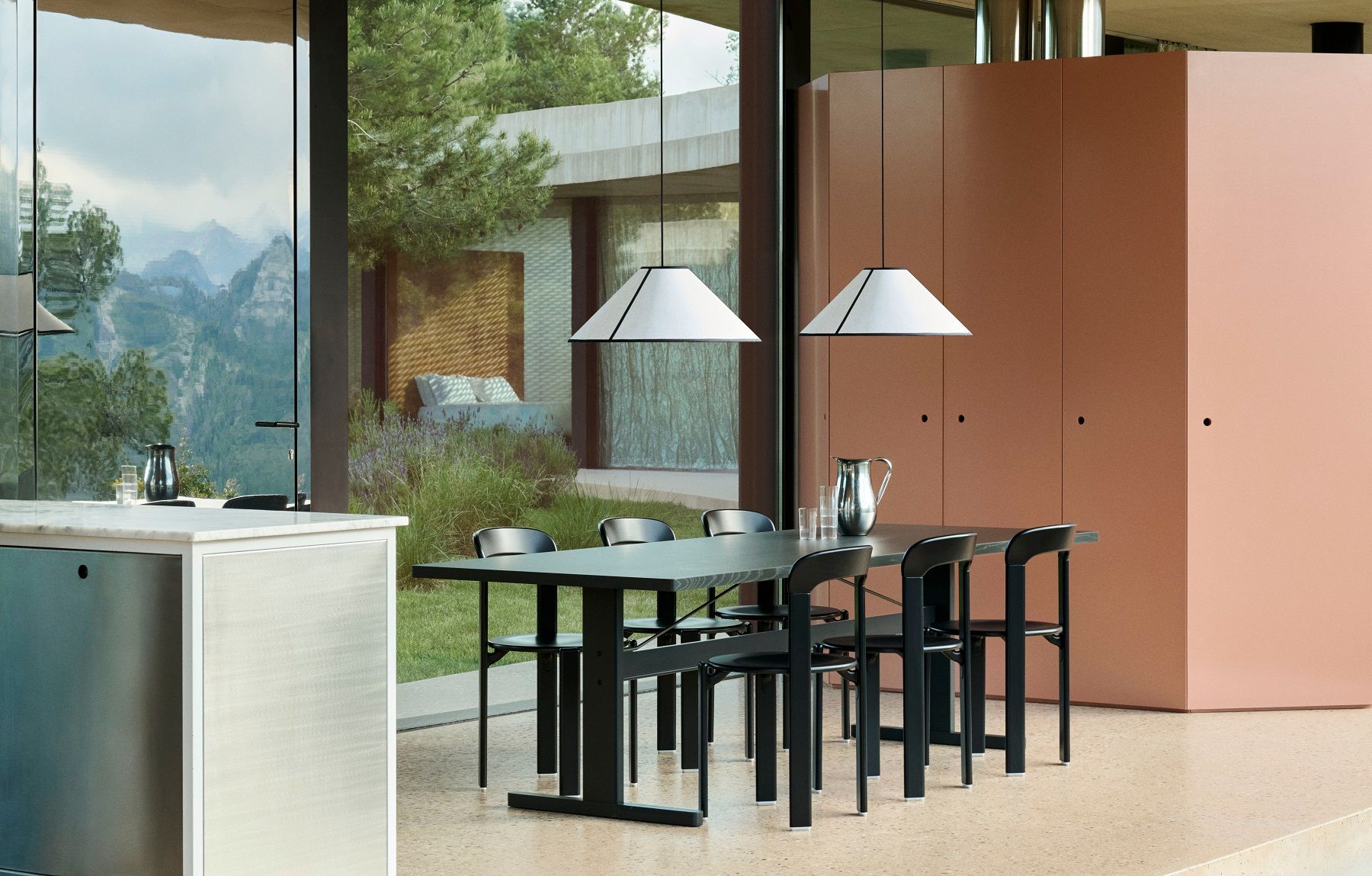 Zwei weiße Hay Ava Cone Pendelleuchten über einem Esstisch mit schwarzen Stühlen in modernem Interieur.