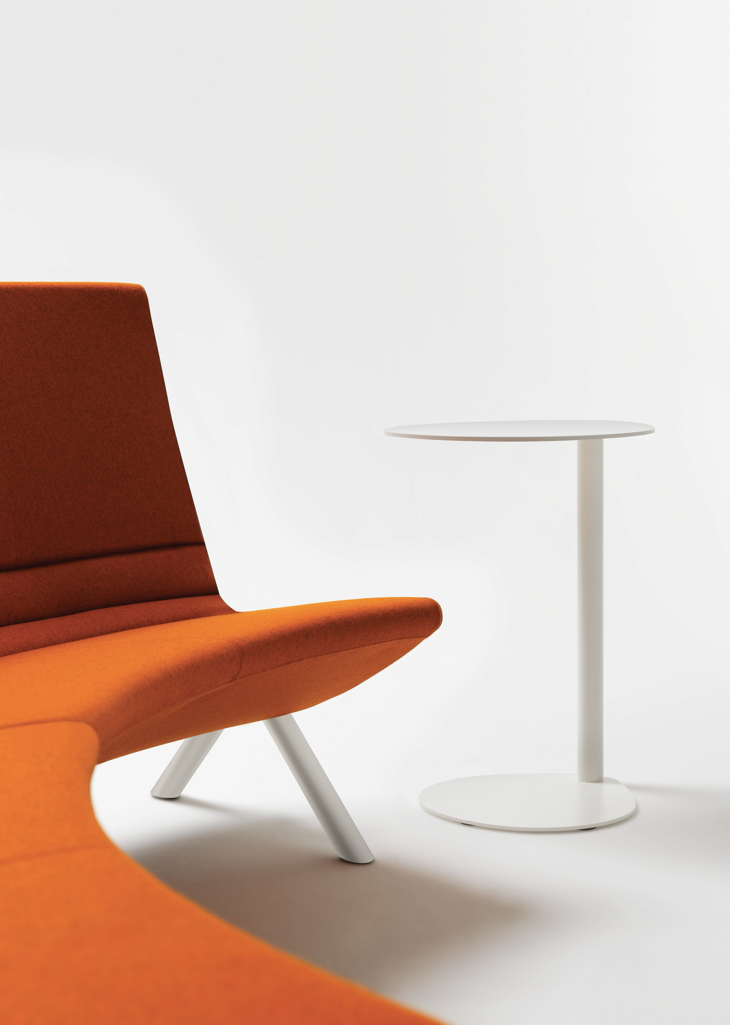 Easy Boy Beistelltisch in Grau neben einem orangefarbenen Sessel auf weißem Hintergrund.
