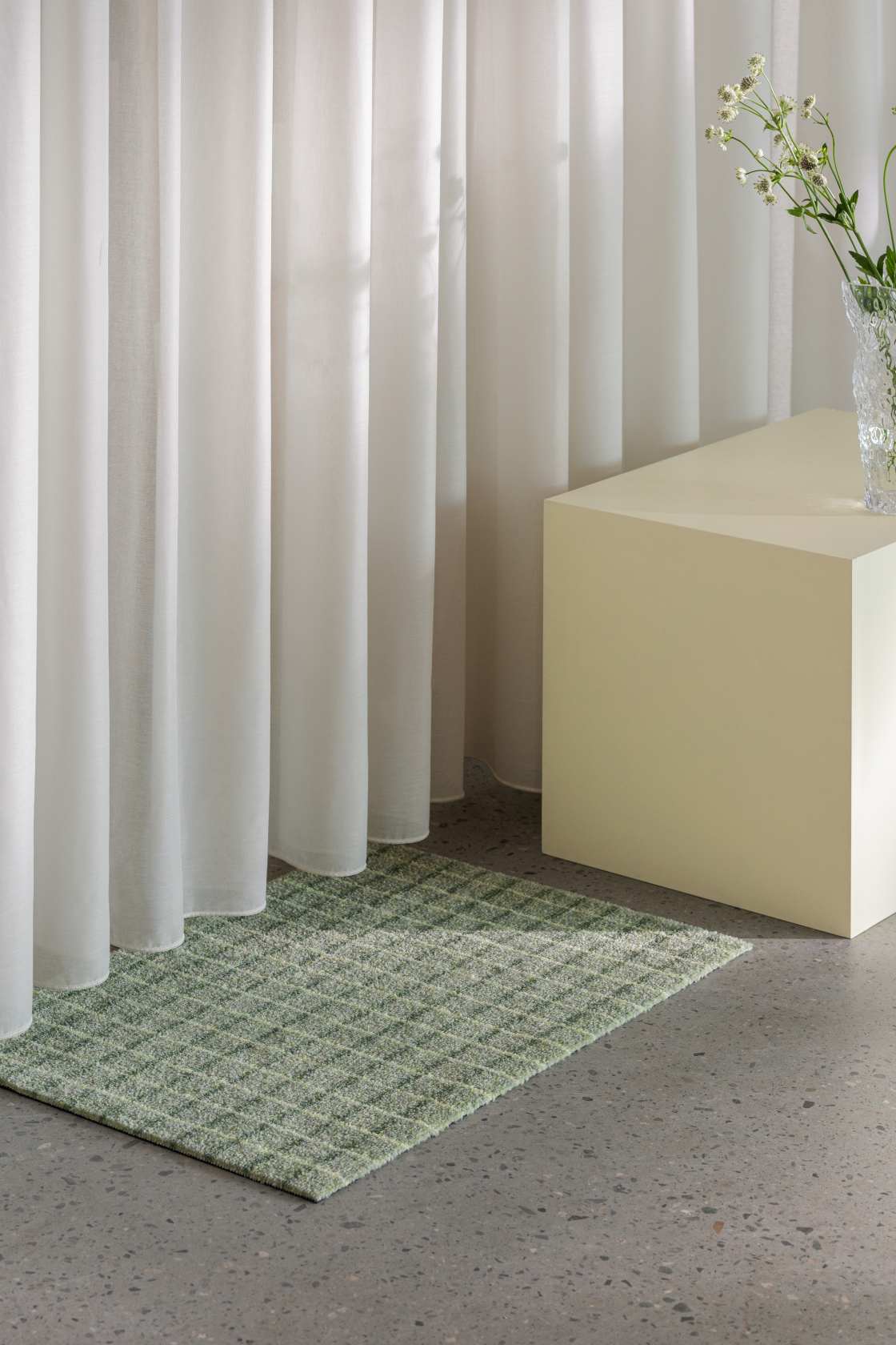 Grüne Grid Fußmatte "Matcha Lemon" von Heymat im Interieur mit Vorhang und Dekoration.