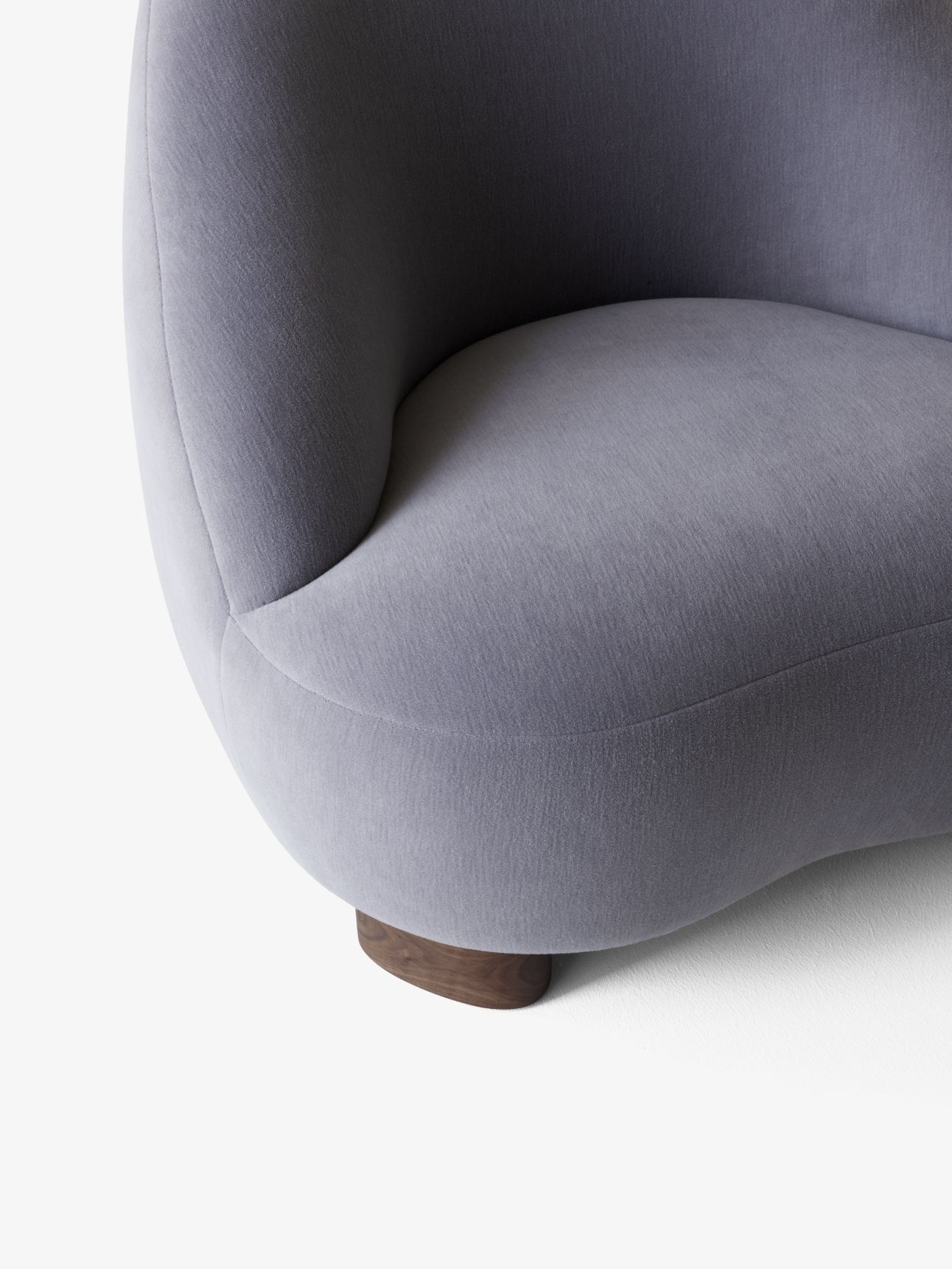 Detailaufnahme des Margas Loungesessels LC1 von AndTradition, grauer Stoffbezug und dunkles Holzfußgestell.