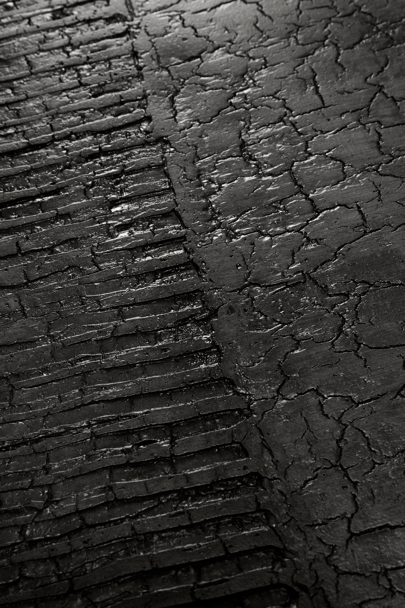 Detailaufnahme der schwarzen, rissigen Oberfläche des Luna Couchtischs im Lava Linear Design von Ethnicraft.