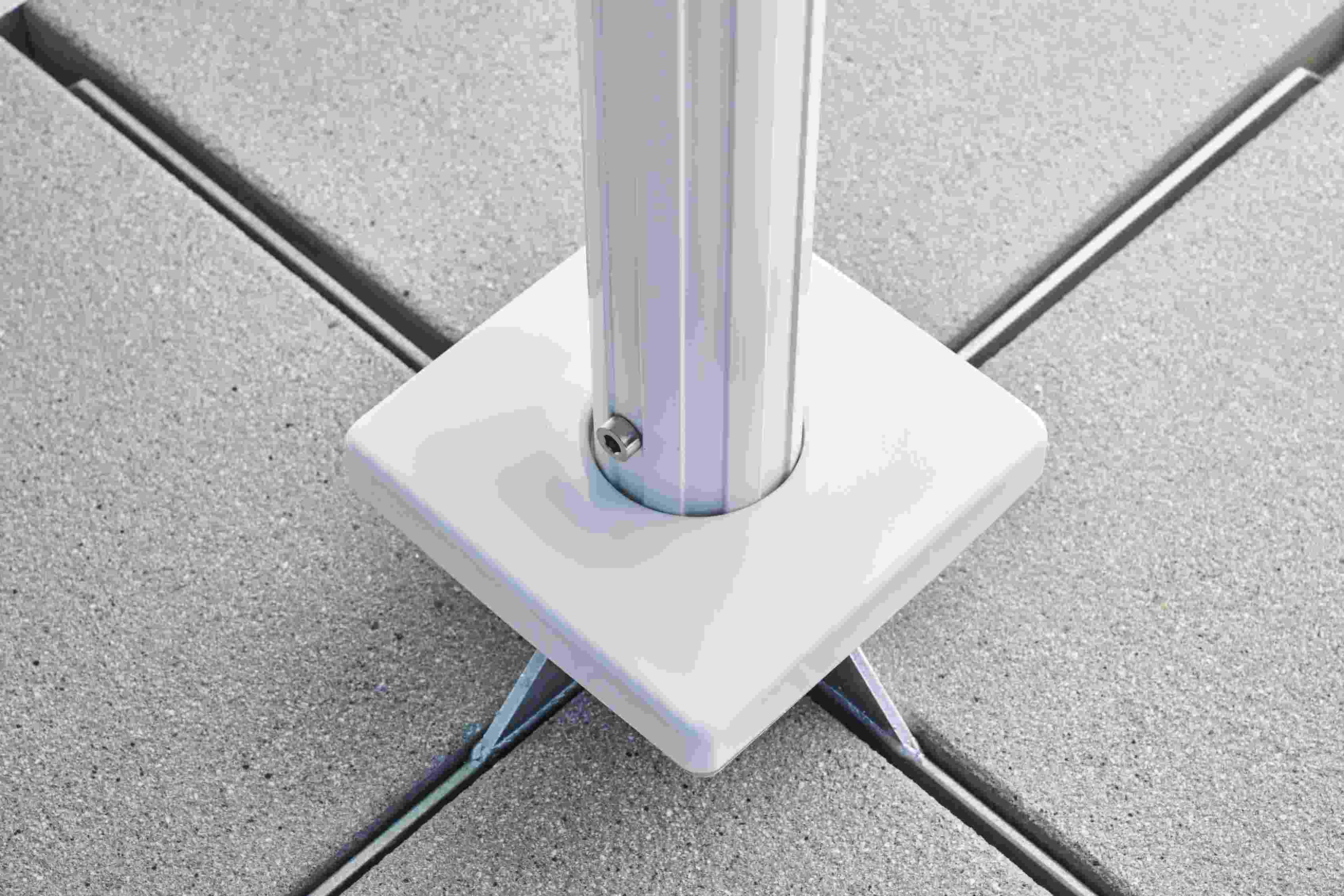 Detailaufnahme des Weishäupl Sonnenschirmfußes aus weißem Metall auf grauem Steinboden, ideal für Terrasse und Garten.