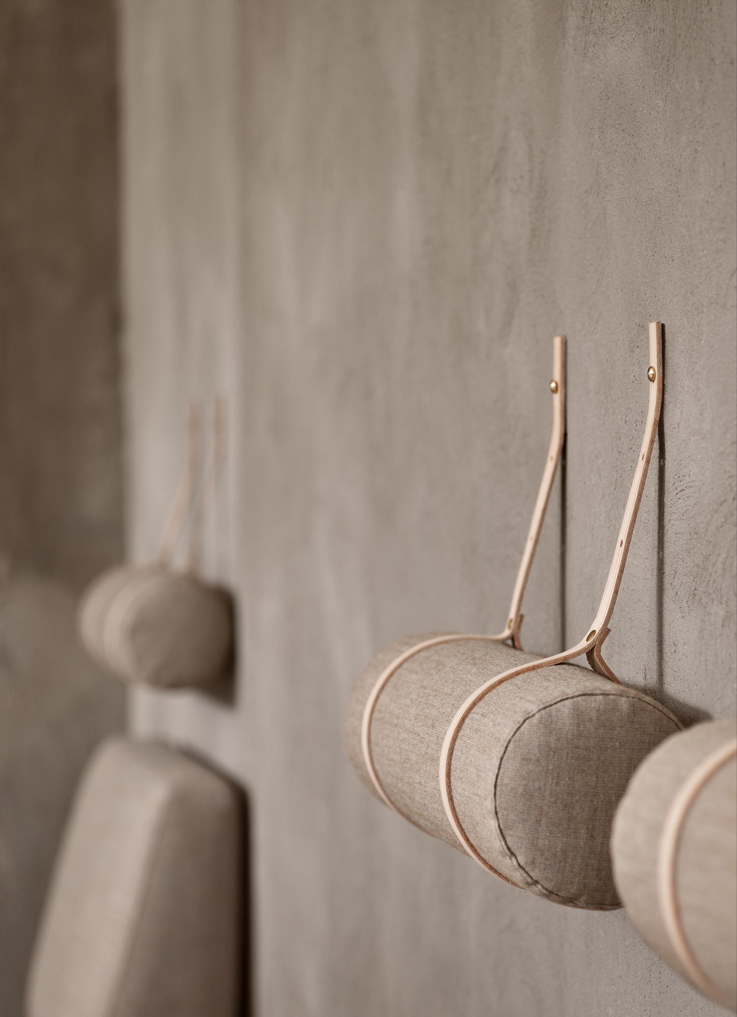 Detailaufnahme des Carl Hansen BM0865 Daybed Tagesbett Zubehörs: Kissen und Nackenrolle an der Wand befestigt.