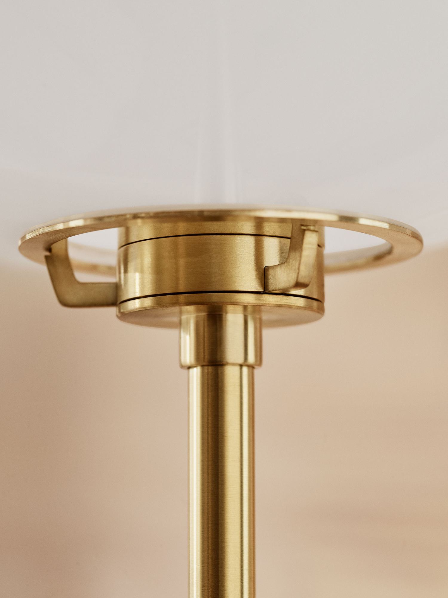 Detailaufnahme der Fritz Hansen Stehleuchte Clam in Messing mit weißem Lampenschirm.
