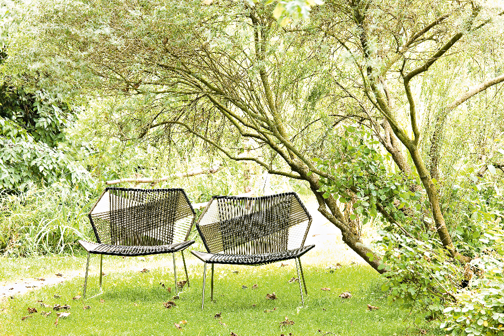 Zwei Tropicalia TR0 Outdoor Sessel von Moroso aus Polymer im Garten unter einem Baum.