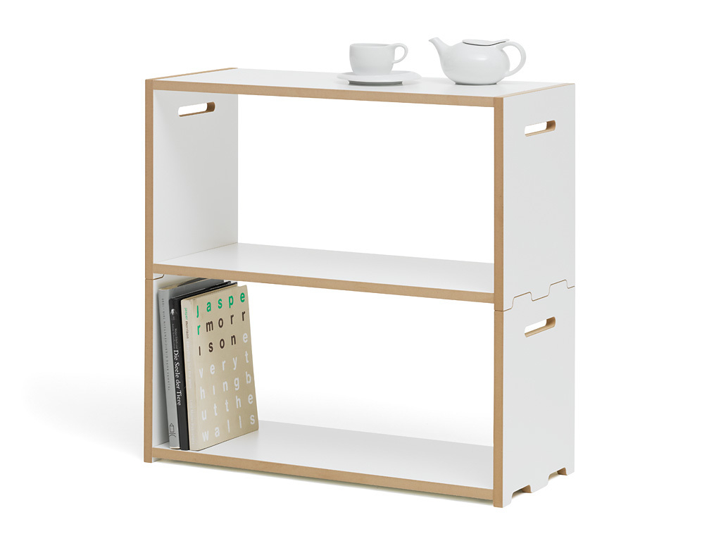 Weißes Tojo Regal Anbaumodul mit zwei Fächern, Büchern, Teekanne und Tasse.