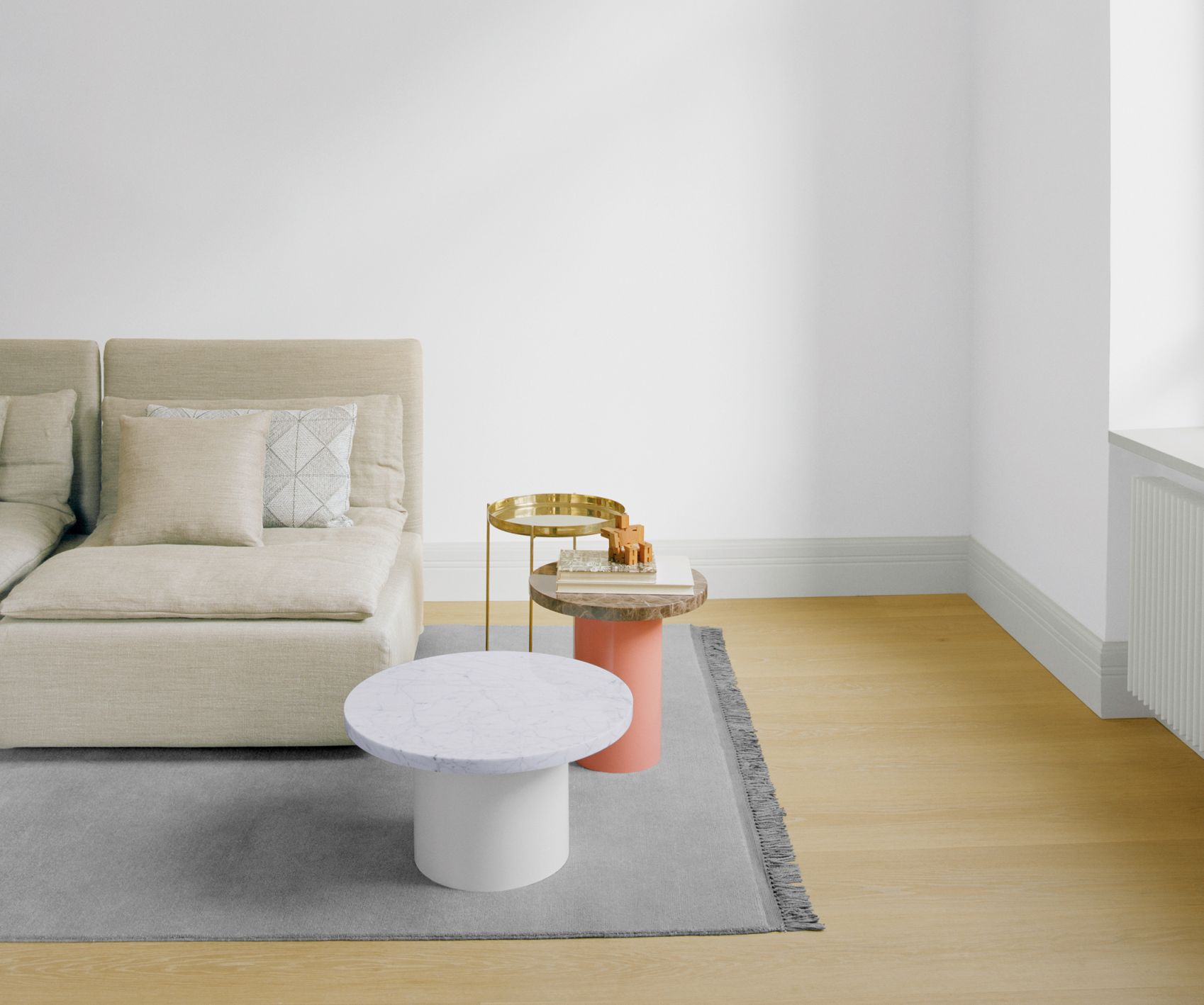Heller Wohnraum mit Sofa, Teppich und Enoki Beistelltisch von e15 mit Marmorplatte und weißem Fuß.