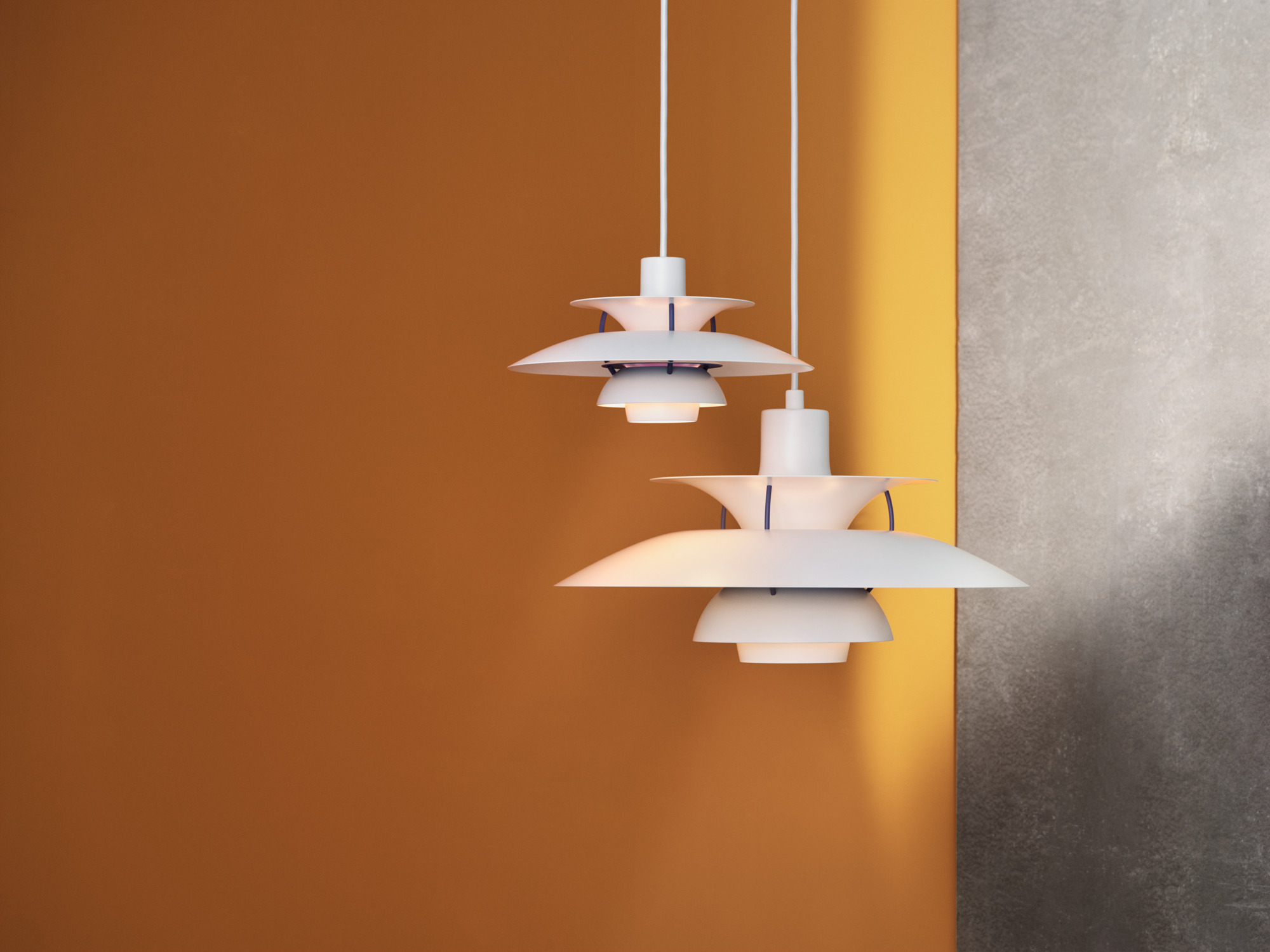 Zwei moderne, weiße Pendelleuchten mit Schirm vor orangefarbener und grauer Wand. Design Lampe für Wohnzimmer.