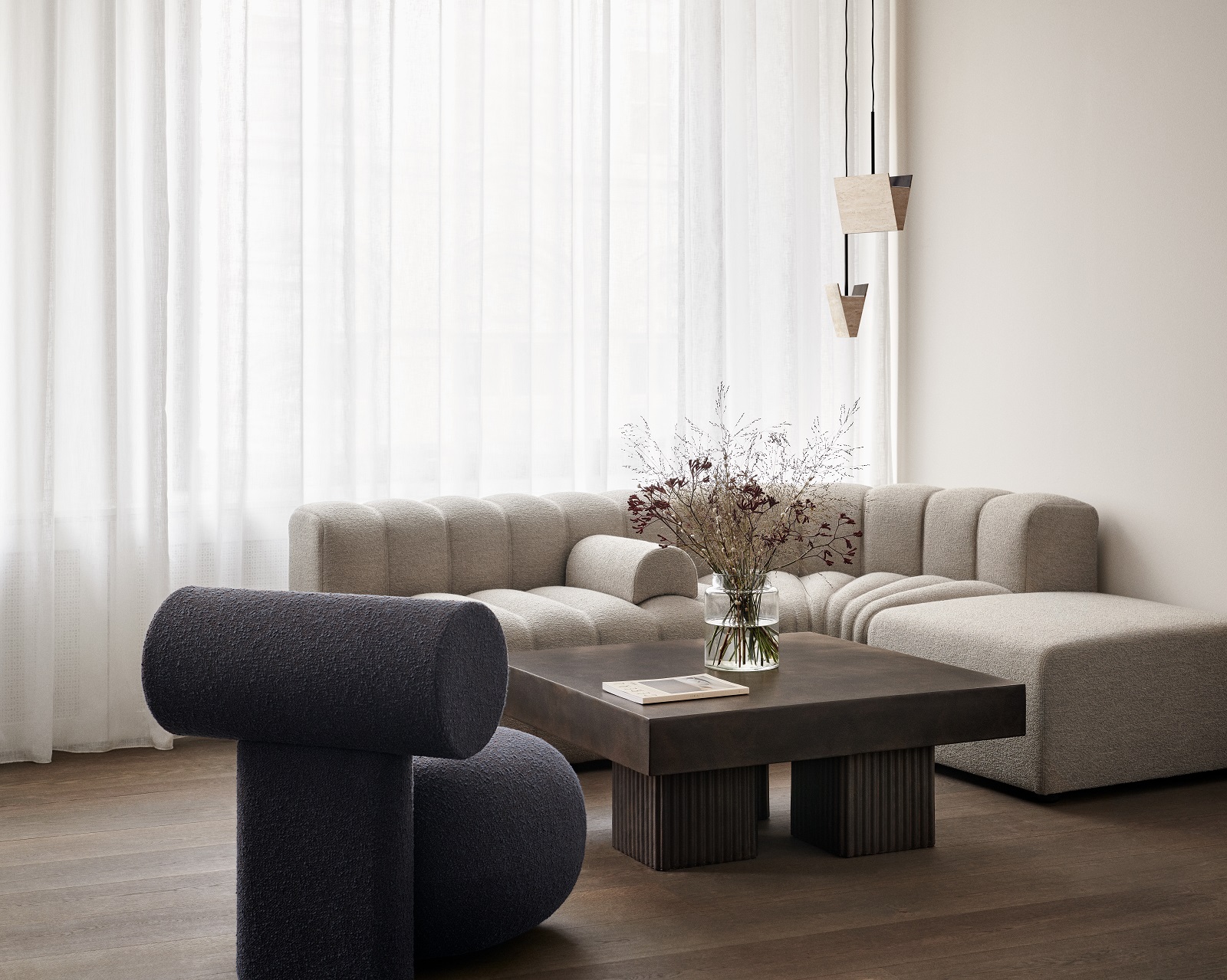 Gear Square Couchtisch von Norr11 im modernen Wohnzimmer mit Sofa, Sessel und Dekoration.