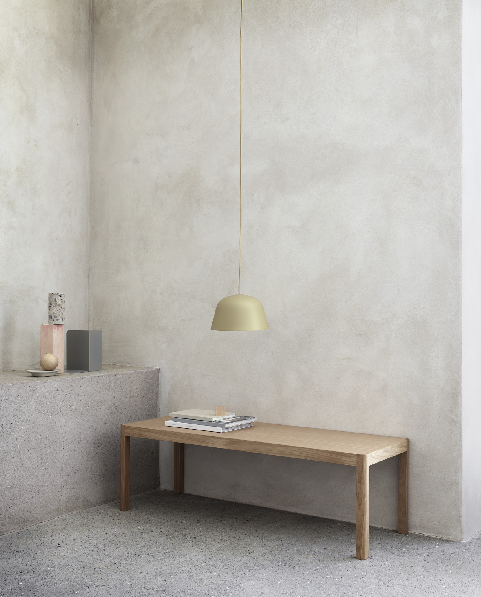 Muuto Workshop Couchtisch aus Eichenholz mit Büchern und einer Pendelleuchte in minimalistischem Interieur.