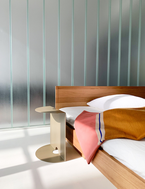 ZIANS Bett Large mit Kopfteil aus Holz, inklusive Nachttisch und farbiger Tagesdecke im Schlafzimmer.