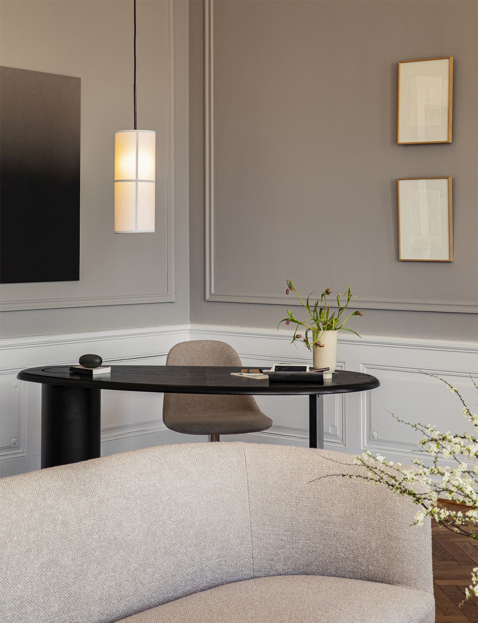 Audo Copenhagen Eclipse Desk Schreibtisch in dunklem Holz mit zylindrischem Fuß und beigem Stuhl.